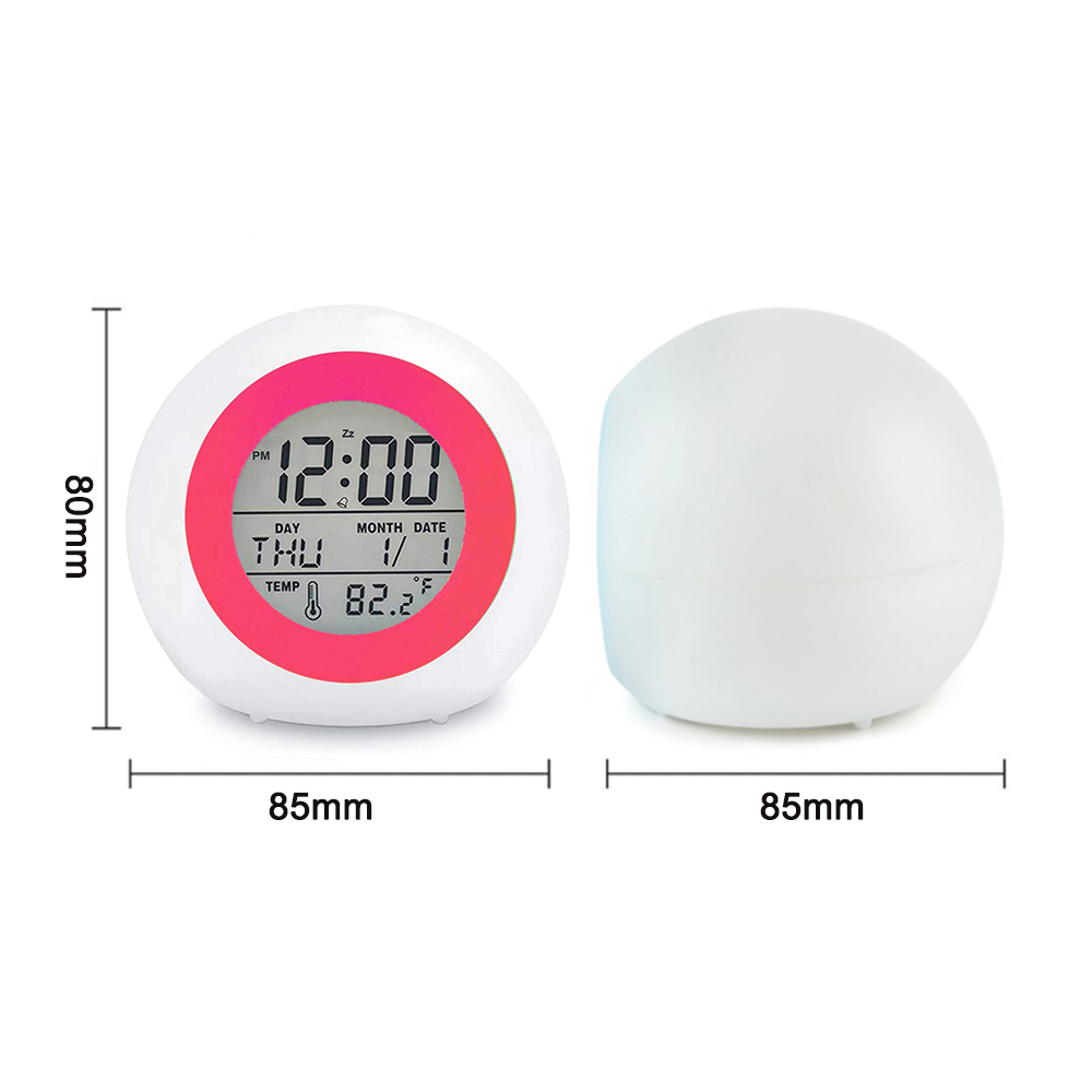 Ein weißer digitaler Wecker mit rosa Ring zeigt 12:00, Donnerstag, 1/1 und 82,2°F an. Daneben ist ein weißes, gewölbtes Objekt.