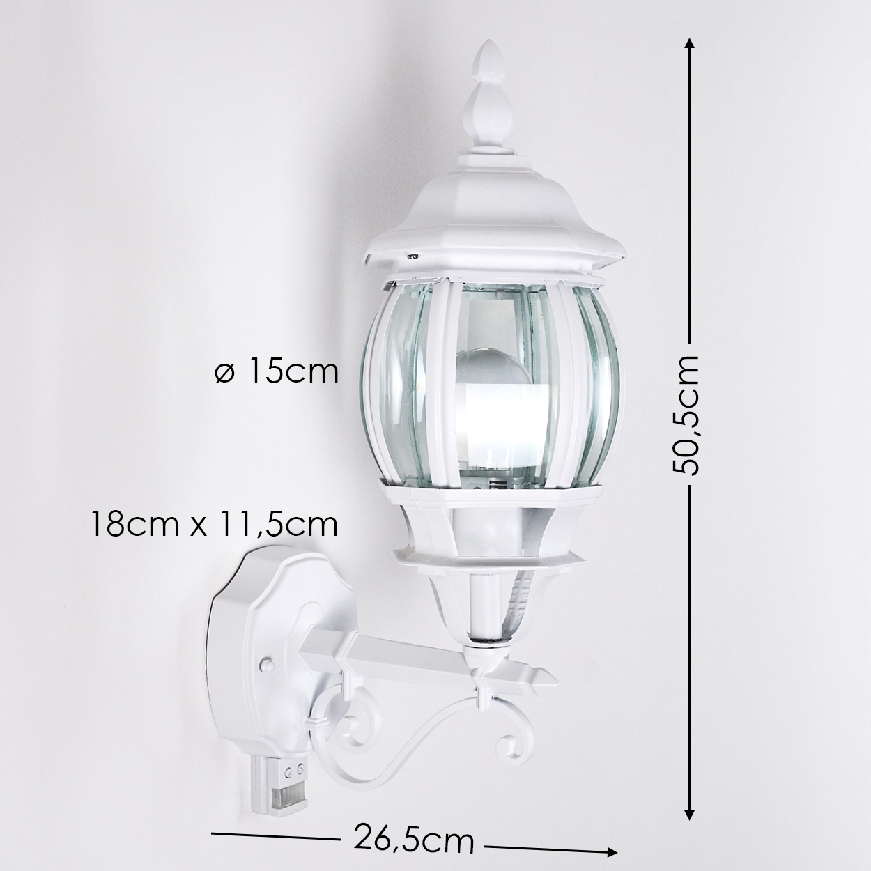 Eine weiße, verzierte Wandlampe mit Glaspaneelen, Abmessungen notiert. Sie ist an einer weißen Wand montiert. Messungen sind um die Lampe angezeigt.