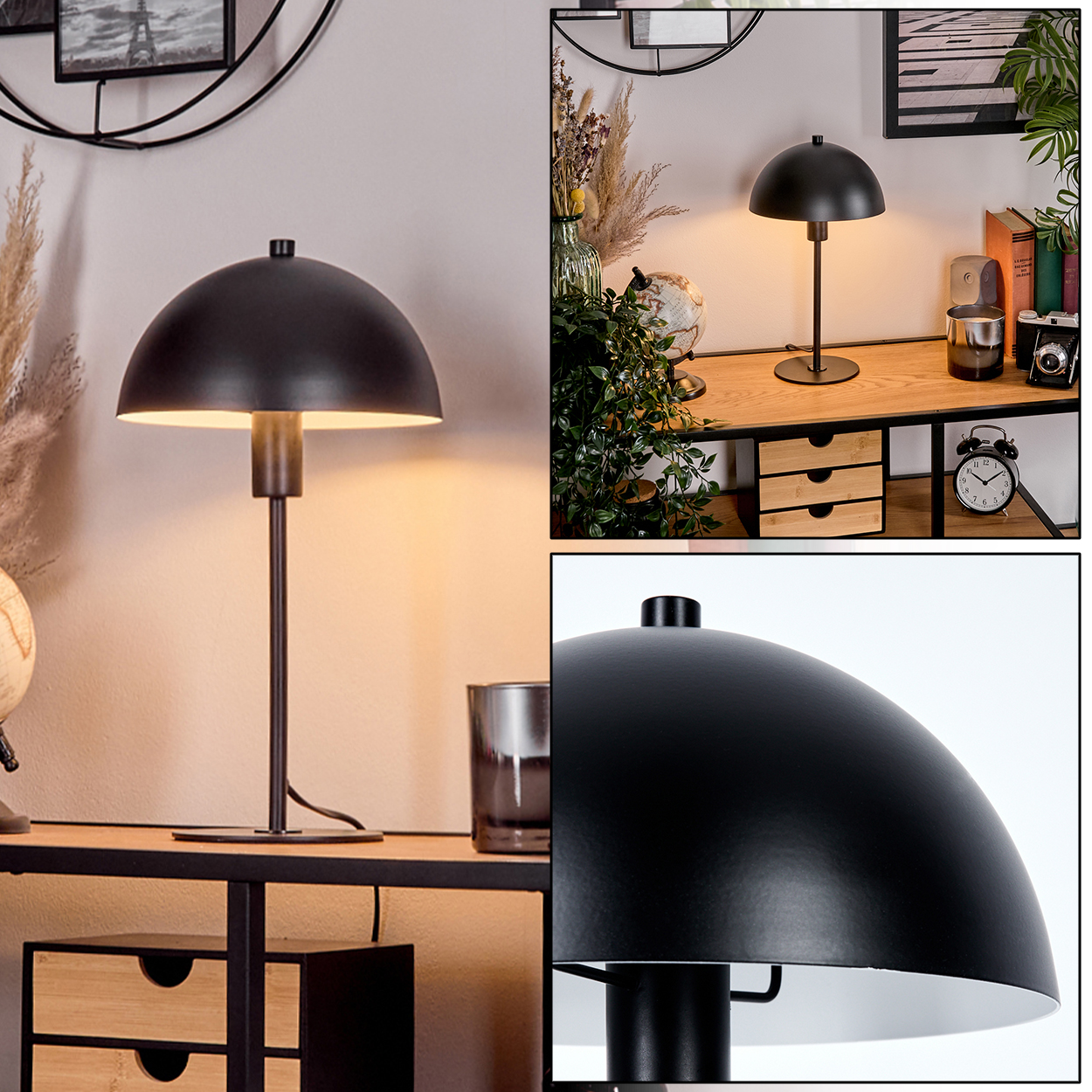 Eine schwarze Schreibtischlampe mit einem kuppelförmigen Schirm. Die Lampe steht auf einem Holztisch mit Schubladen. Weitere Gegenstände sind eine Uhr und Pflanzen.