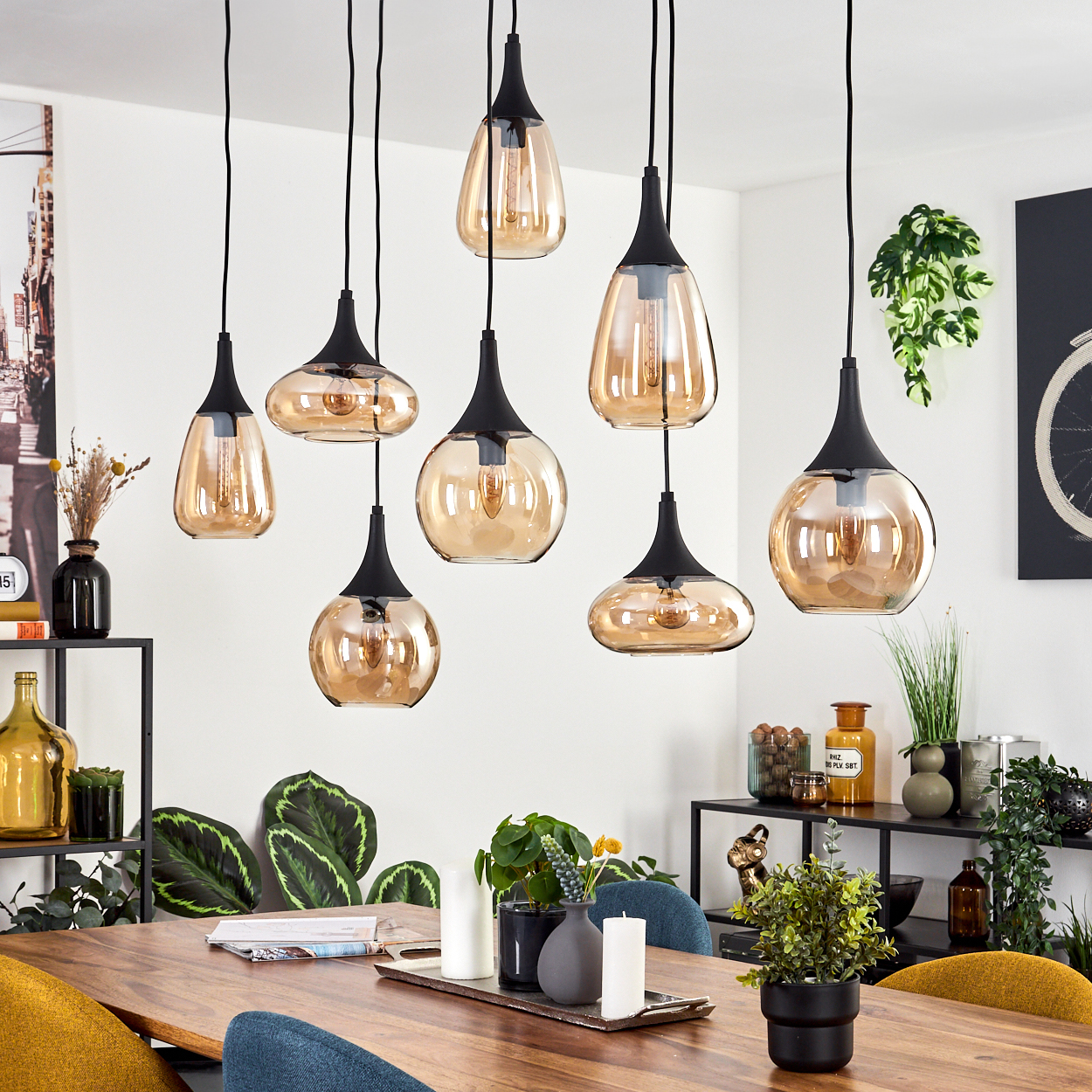 Ein Esszimmer mit mehreren Pendelleuchten, einem Holztisch und verschiedenen Dekorationsartikeln auf Regalen.