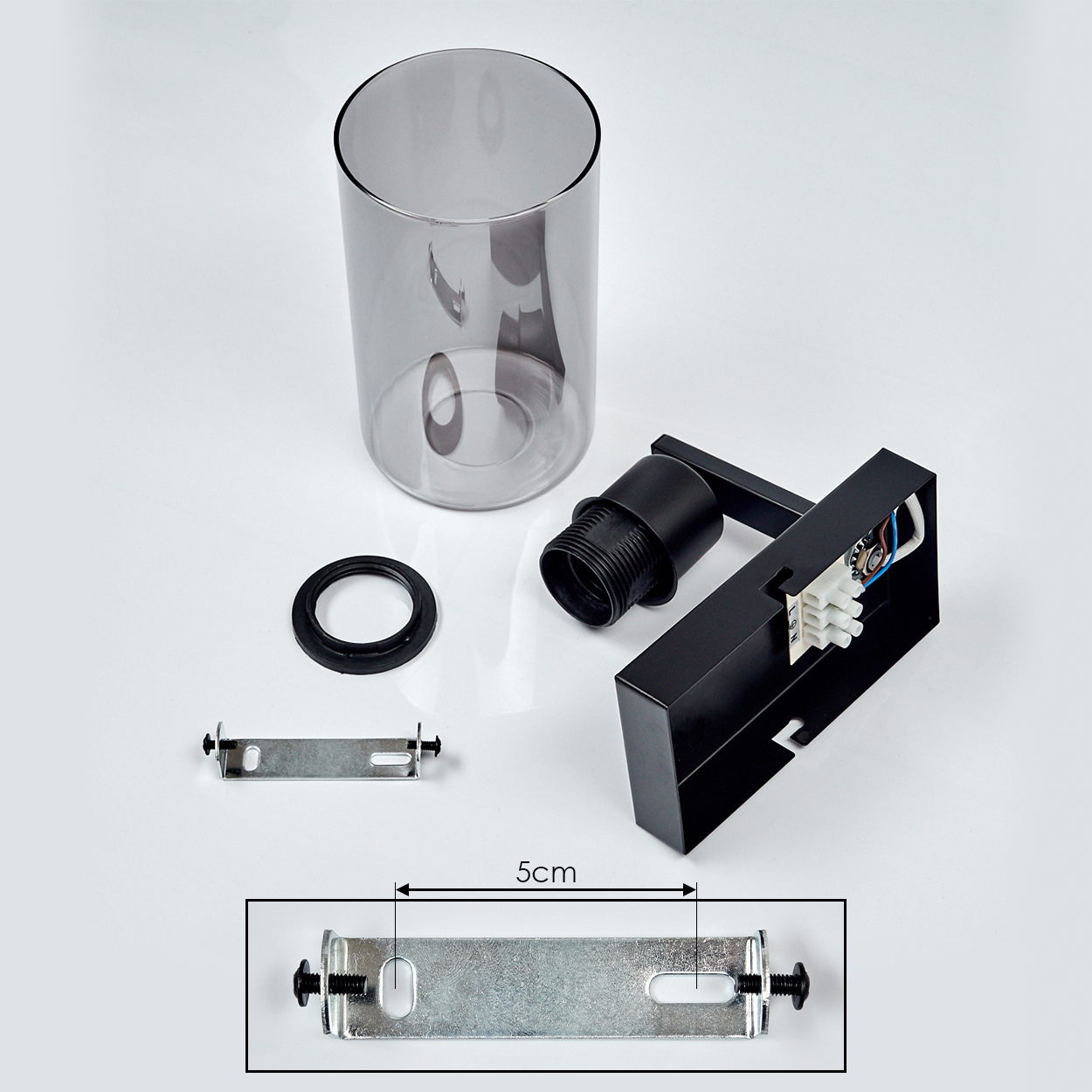 Komponenten einer Lampe: Glasschirm, schwarze Lampenfassung, Metallhalterung, schwarzer Ring und eine 5 cm Messung auf einer Halterung.