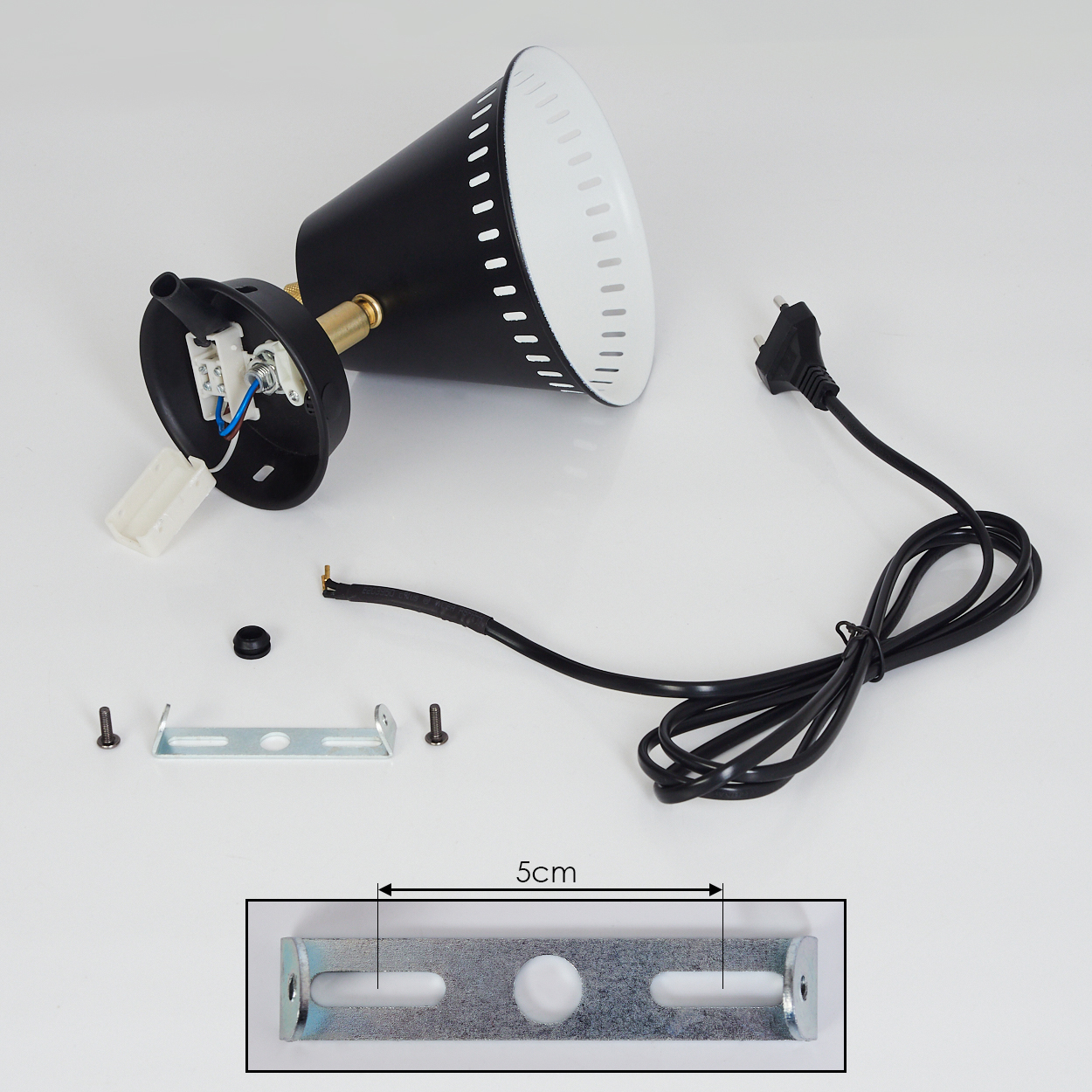 Eine zerlegte schwarz-weiße Lampe auf einer weißen Oberfläche mit ihren Teilen und einer Halterung.