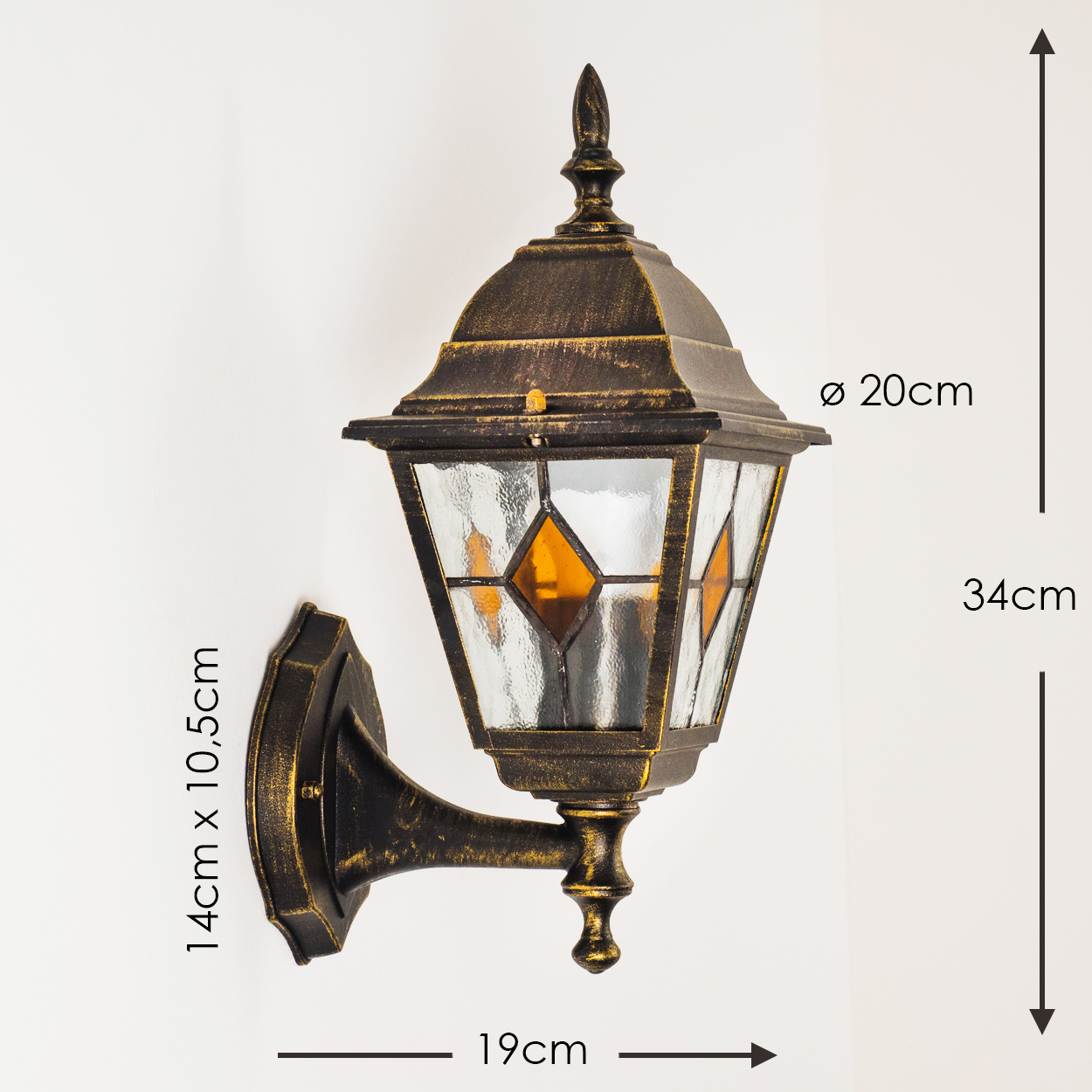 Eine Wandleuchte im antiken Stil mit Maßen. Sie ist goldbraun, hat Glasscheiben und eine nach oben gerichtete Spitze. An einer weißen Wand montiert.