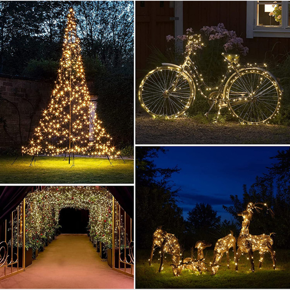 Verschiedene Weihnachtsdekorationen im Freien, beleuchtet mit warmweißen Lichtern. Enthält einen Baum, ein Fahrrad, einen Tunnel und Hirschskulpturen.