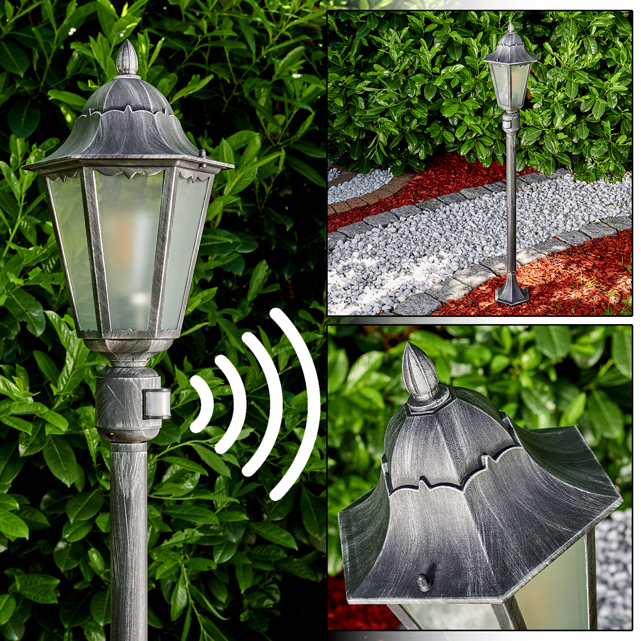 Eine graue Außenlampe mit Bewegungssensor. Grüne Büsche bilden den Hintergrund. Die Lampe befindet sich neben einem Steinweg und roter Mulche.