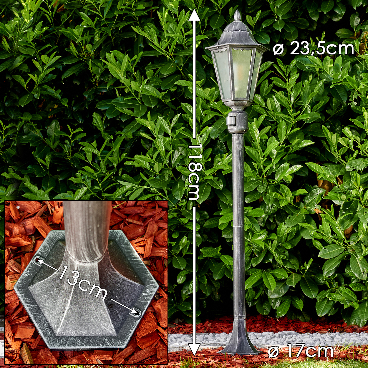 Eine hohe, graue Gartenlaterne steht vor grünen Büschen. Maße für Höhe und Durchmesser sind angegeben.