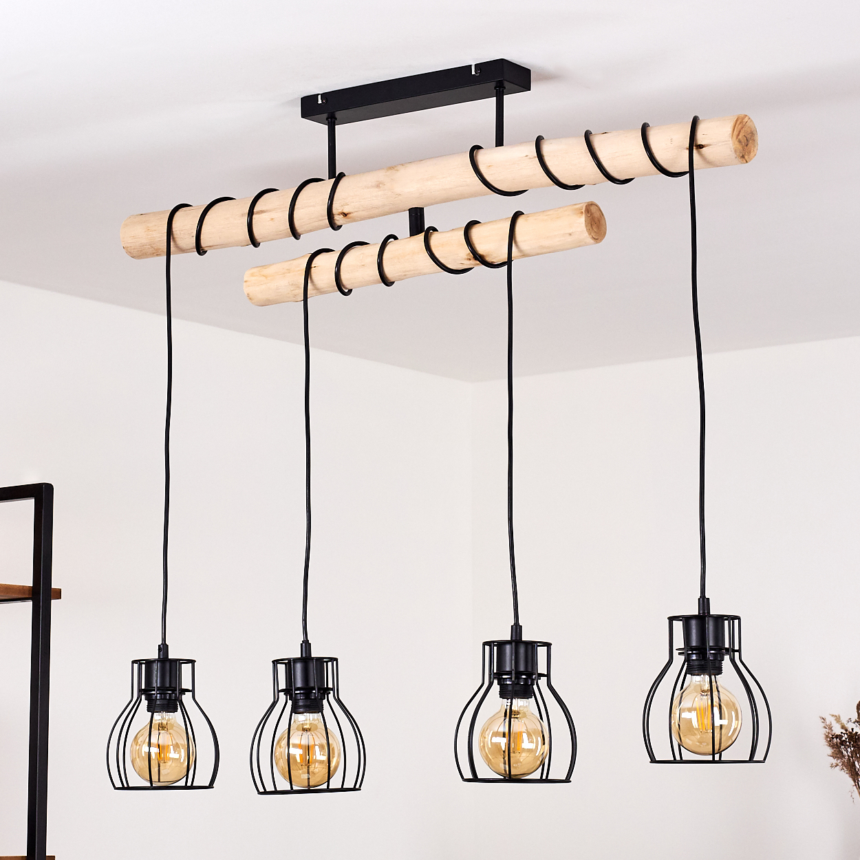 Moderne Deckenleuchte mit Holzbalken und vier schwarzen Käfig-Pendelleuchten mit warmen Glühbirnen, die von der Decke hängen.