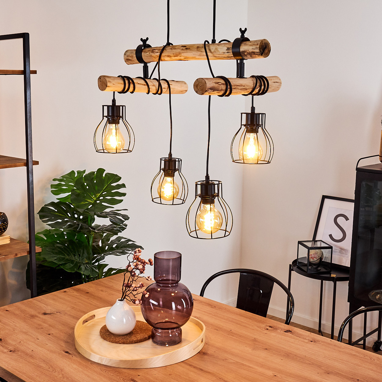 Ein Holztisch mit einem Tablett mit Vase und Deko. Darüber eine Holzbalken-Lichtleuchte mit vier Hängelampen.