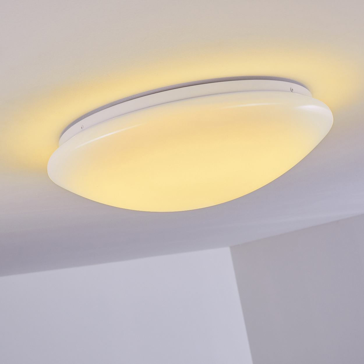 Eine weiße, ovale Deckenlampe mit gelbem Schein beleuchtet den Raum. Der Hintergrund zeigt eine weiße Decke und Wände.
