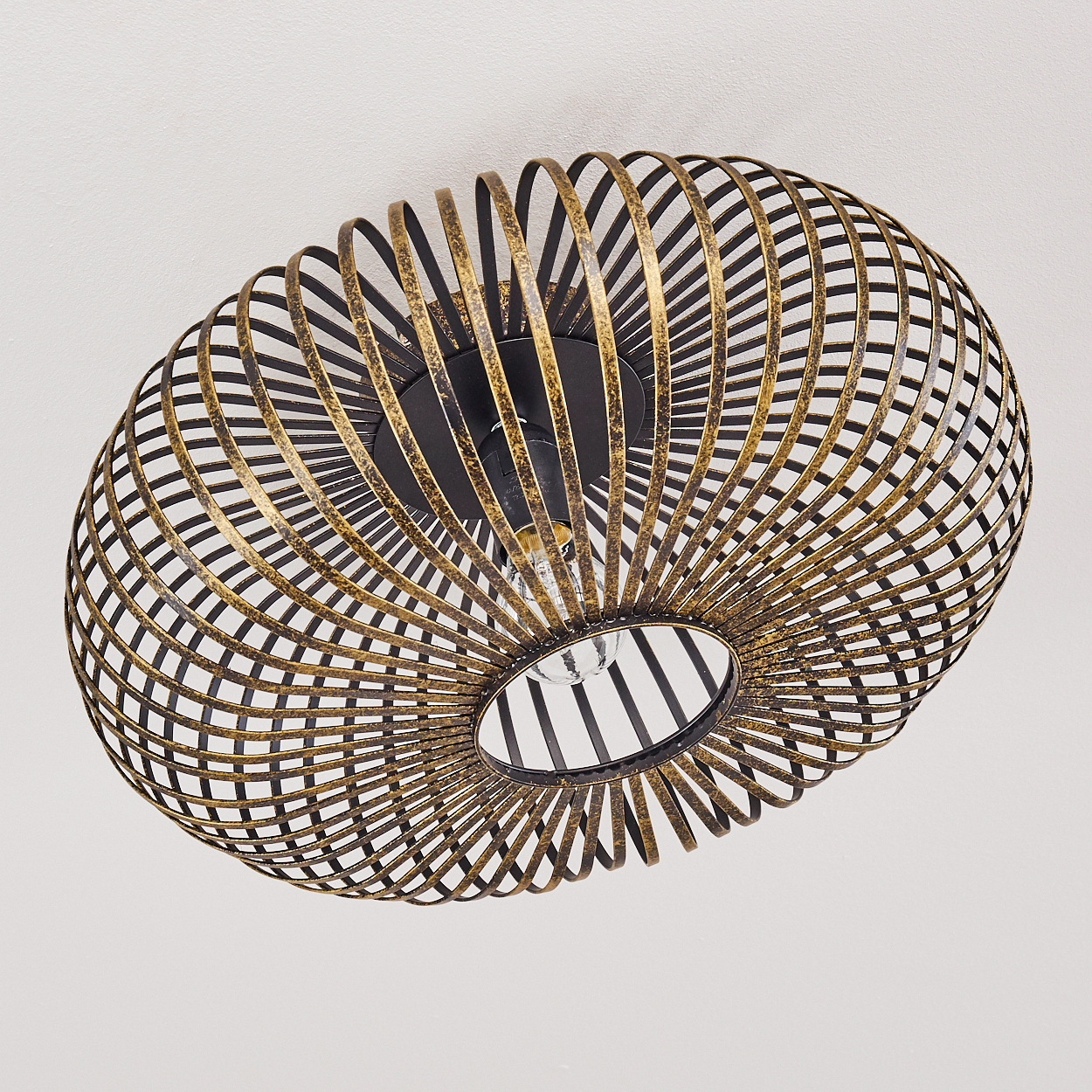 Dekorative Deckenleuchte. Sie hat ein käfigartiges Design mit Gold- und schwarzem Metall. Der Hintergrund ist eine weiße Decke.