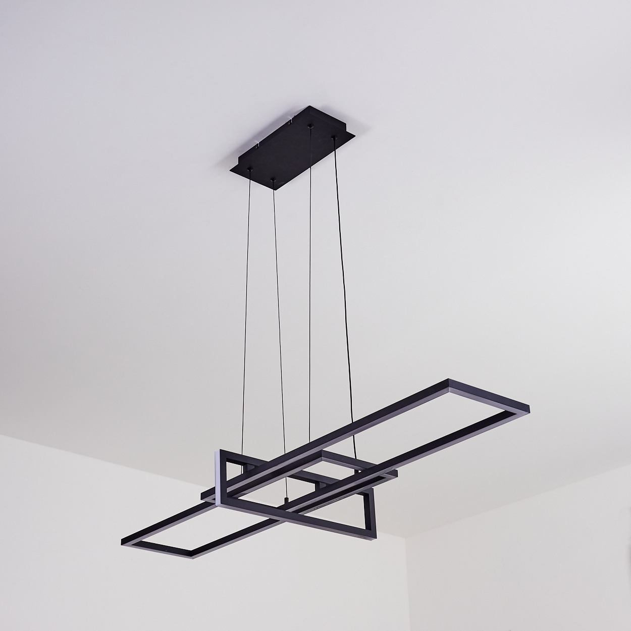 Moderne schwarze geometrische Deckenleuchte, die von der weißen Decke abgehängt ist. Merkmale: rechteckige und quadratische Formen mit dünnen schwarzen Linien.