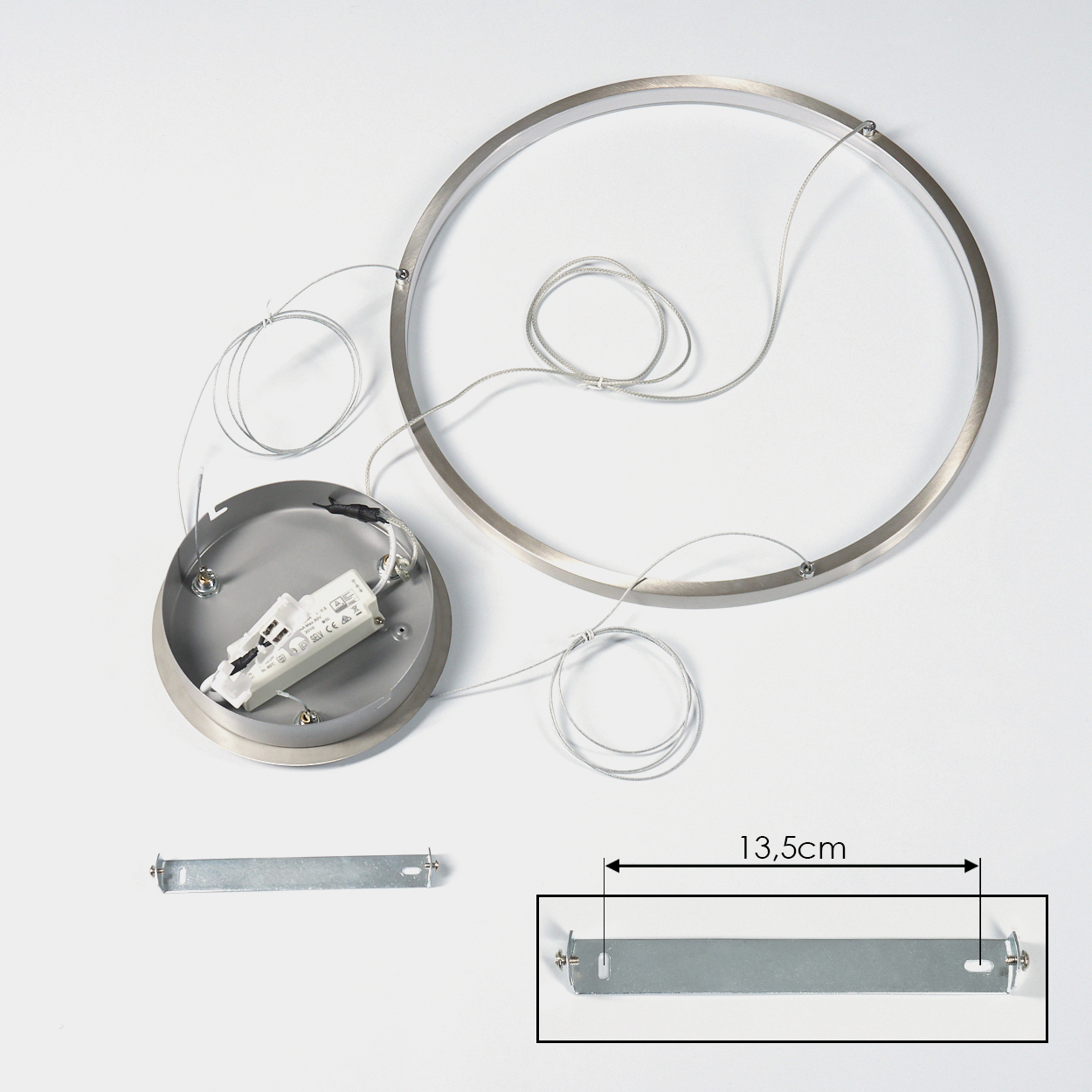 Zerlegte silberne Leuchte mit kreisförmigem Rahmen, rundem Sockel, Drähten und einer rechteckigen Metallhalterung. Die Halterung ist 13,5 cm lang.