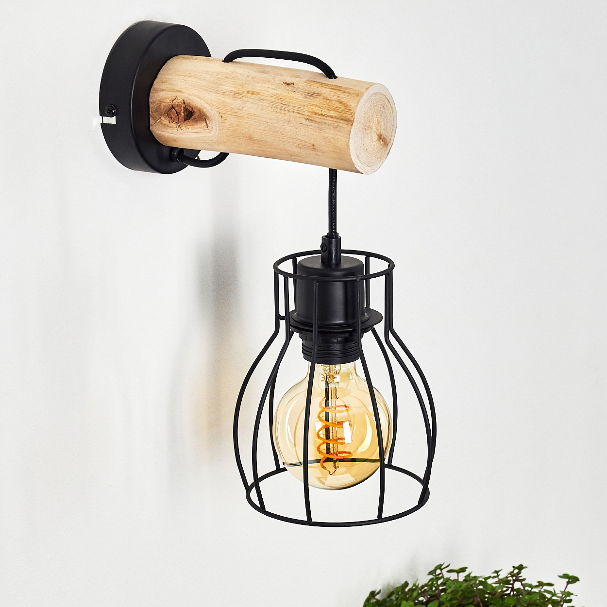 Eine Wandlampe mit Holzbalken, schwarzem Käfig und Glühbirne.