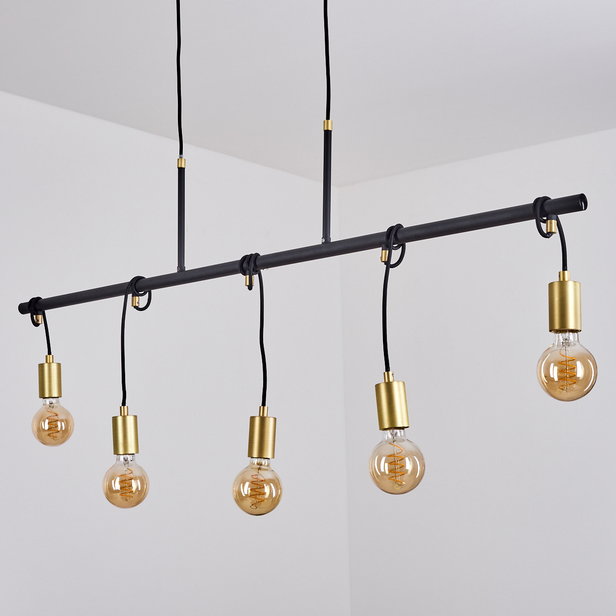 Ein moderner Kronleuchter mit fünf Edison-Glühbirnen. Er hat einen schwarzen Metallrahmen und goldene Akzente vor weißem Hintergrund.