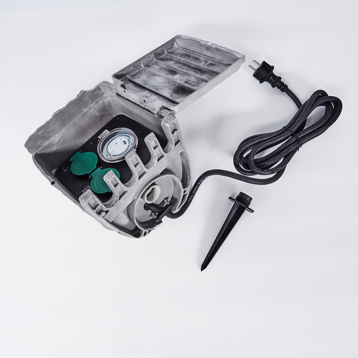 Offene graue elektrische Zeitschaltuhr für den Außenbereich mit grünen Abdeckungen, einem schwarzen Stecker, einem Pflock und schwarzem Kabel.
