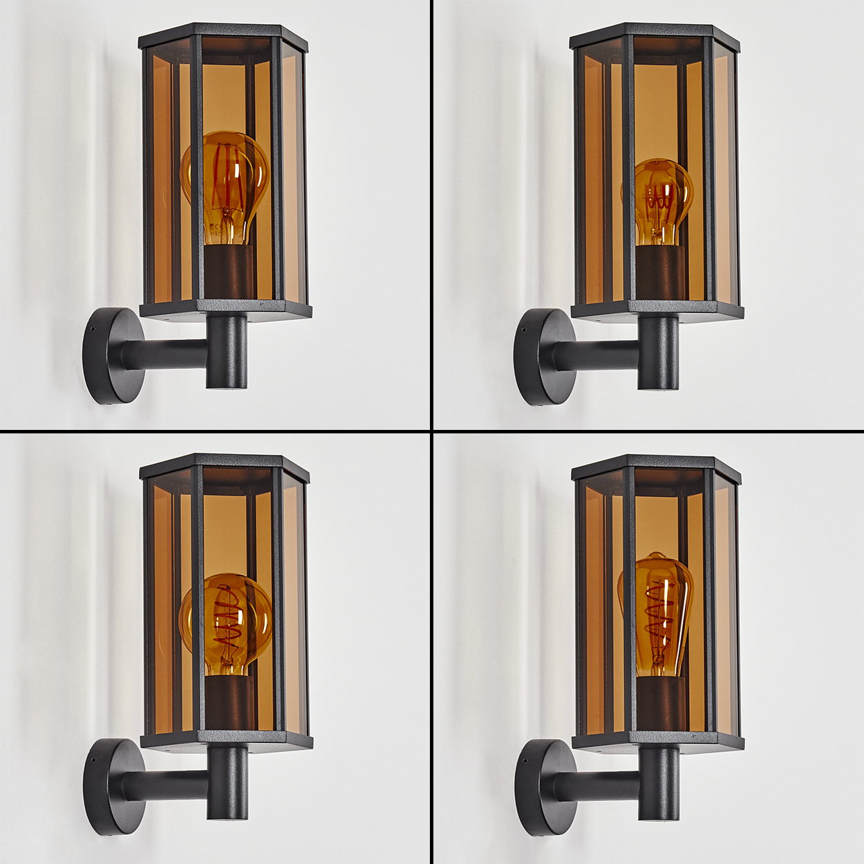 Vier Außenlampen mit bernsteinfarbenem Glas und schwarzen Rahmen sind an einer weißen Wand montiert. Jede Lampe hat eine Glühbirne.