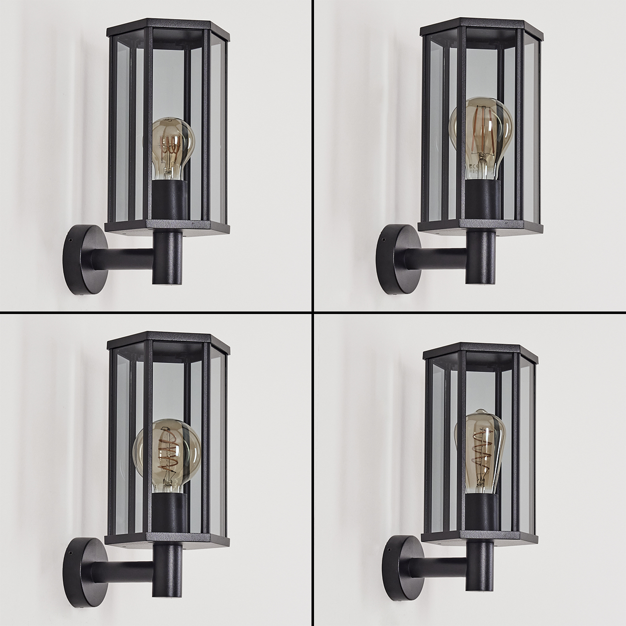 Vier schwarze Wandlampen. Jede hat einen sechseckigen Glasschirm, der eine Glühbirne umschließt. Die Lampen sind an einer weißen Wand befestigt.