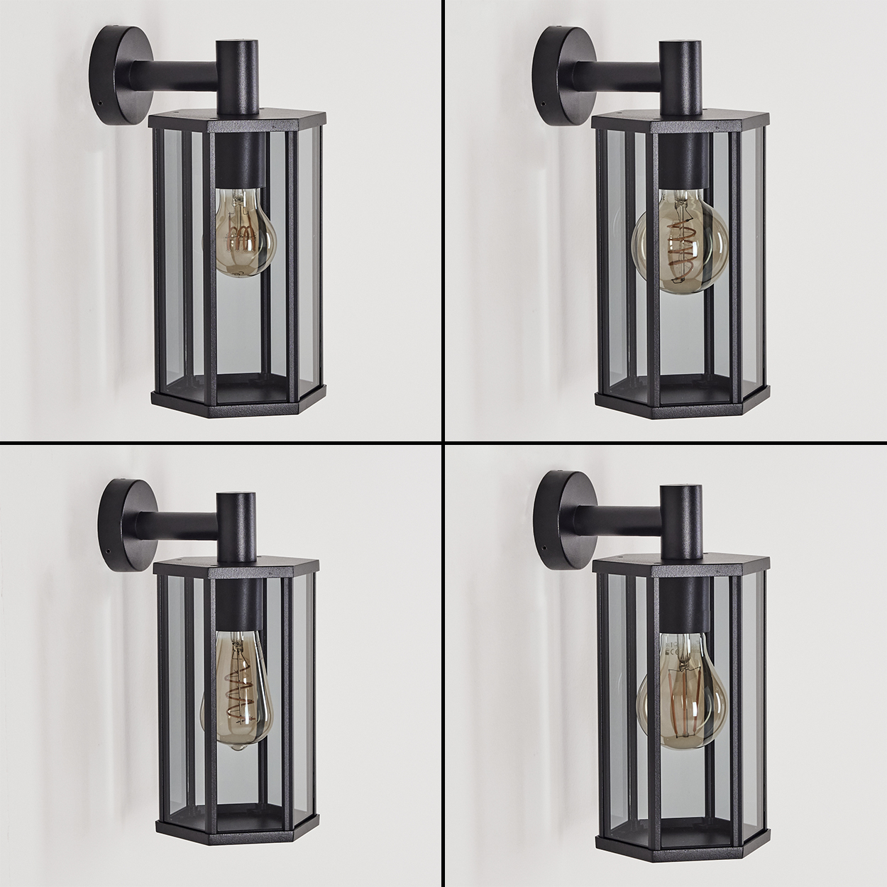 Vier schwarze Wandlampen mit Glaspaneelen und einer Glühbirne im Inneren, an einer weißen Wand montiert.