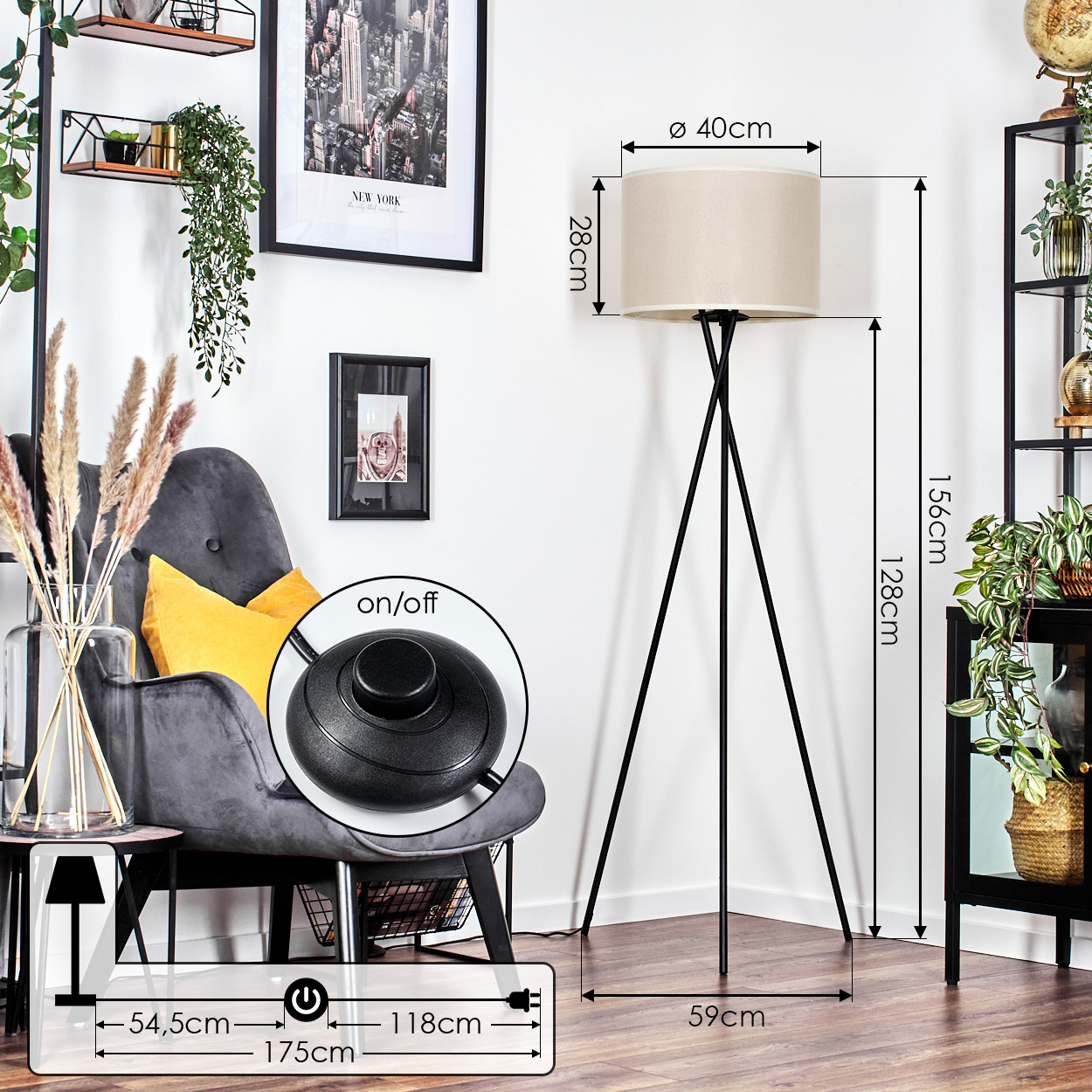 Eine Stehlampe mit beigem Lampenschirm steht in einem Raum. Ein grauer Sessel, Bilder und ein schwarzes Regal sind ebenfalls zu sehen.