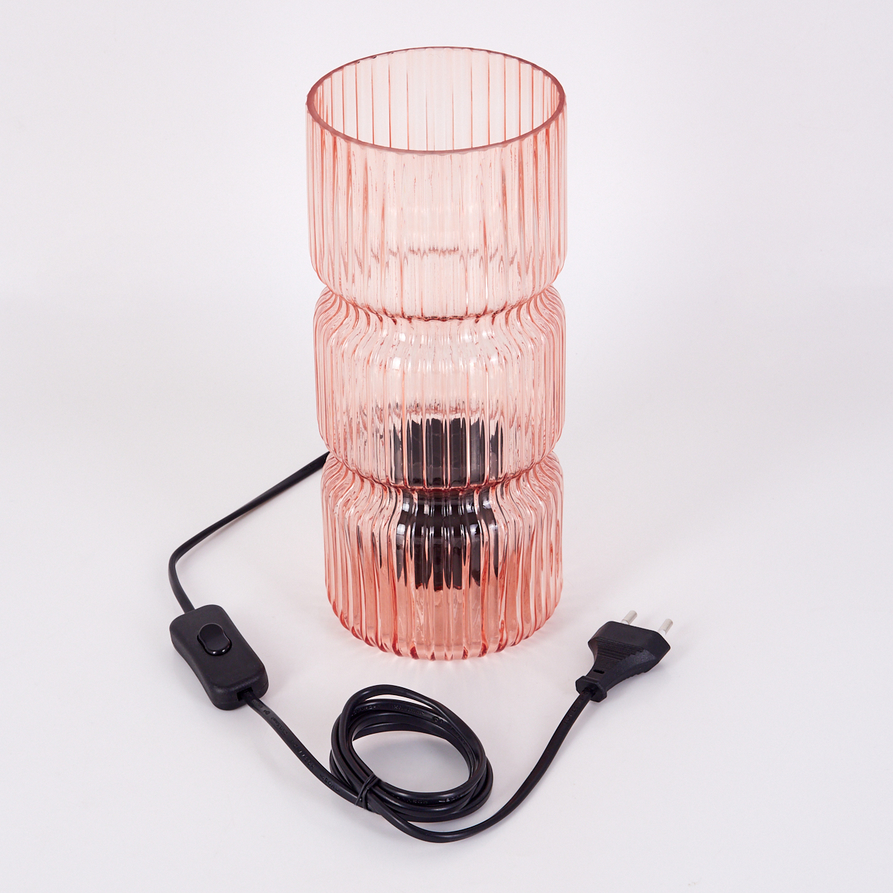 Eine rosa Glas-Tischlampe mit dreistufigem Design. Sie hat ein schwarzes Kabel, einen Schalter und einen Stecker auf weißem Hintergrund.