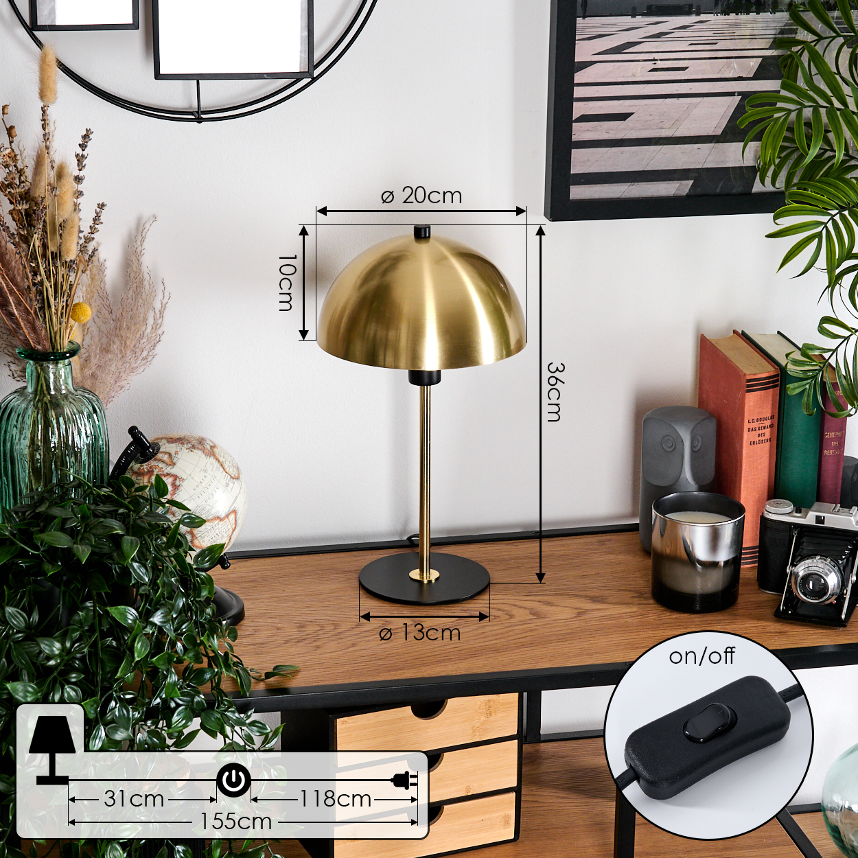 Eine goldene Schreibtischlampe mit schwarzem Fuß steht auf einem Holzschreibtisch. Bücher, eine Kamera und eine Pflanze sind sichtbar.
