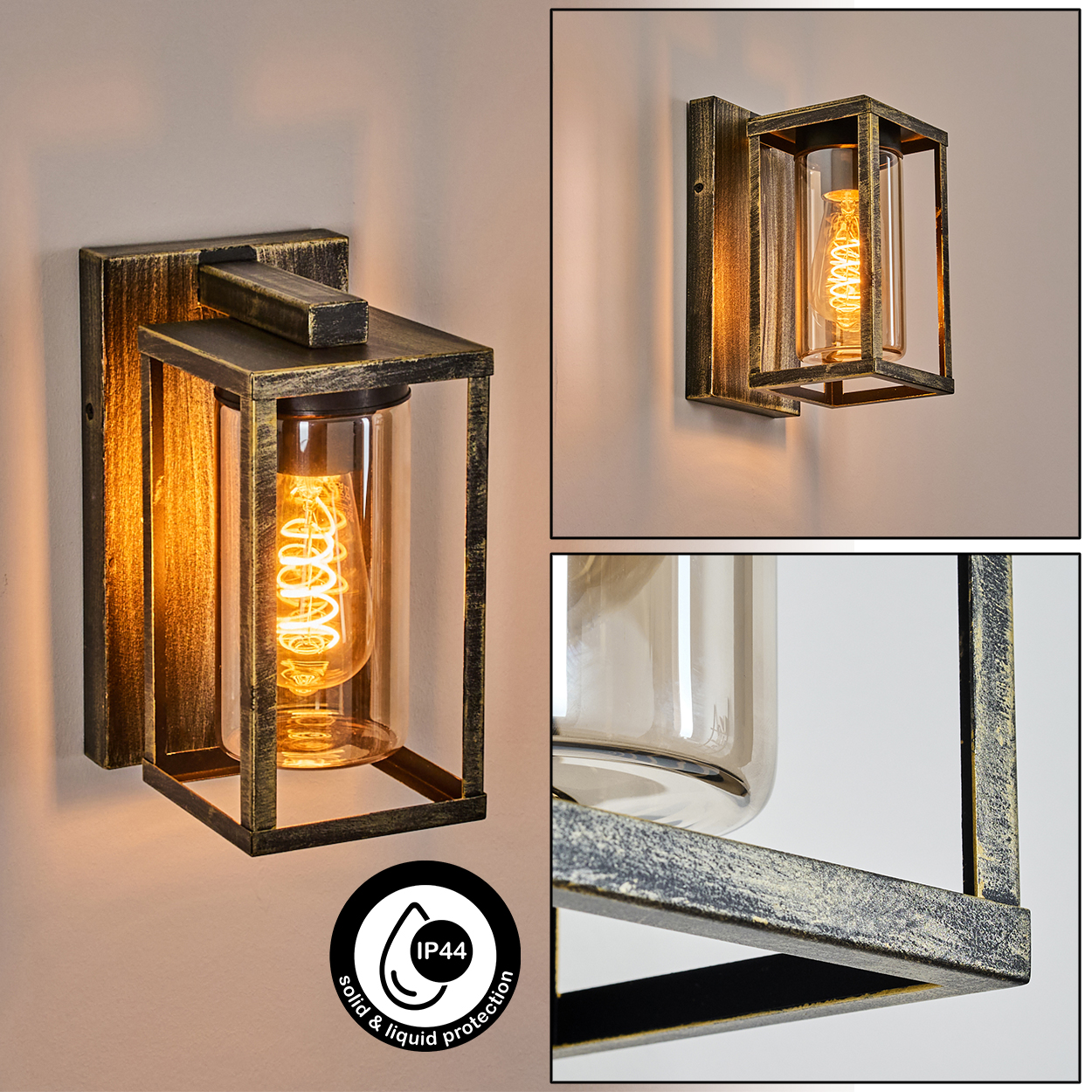 Eine antike Wandlampe mit einer Wendelglühbirne in einem Glaszylinder, umhüllt von einem schwarz-goldenen Metallrahmen, an einer beigen Wand.