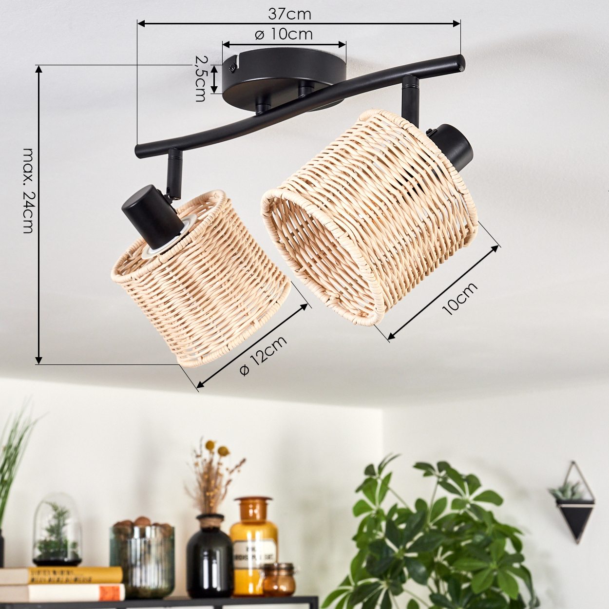 Eine Deckenleuchte mit zwei gewebten Rattanschirmchen. Schwarz, mit im Bild beschrifteten Maßen. Im Hintergrund Pflanzen und Dekoration.
