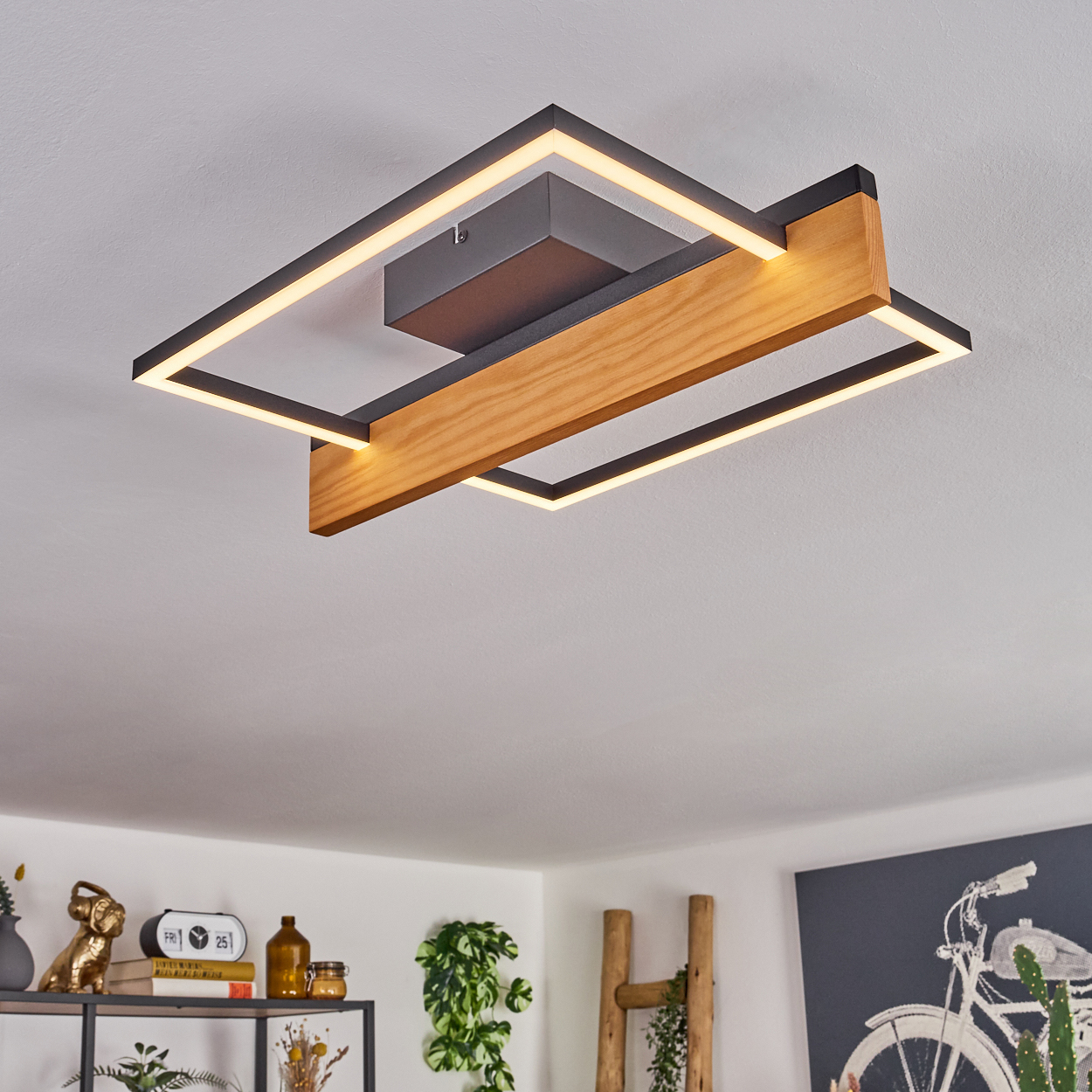 Deckenleuchte. Holzbalken und schwarzer Rahmen mit weißem Licht. Pflanzen und Dekor im Hintergrund, mit weißer Decke.