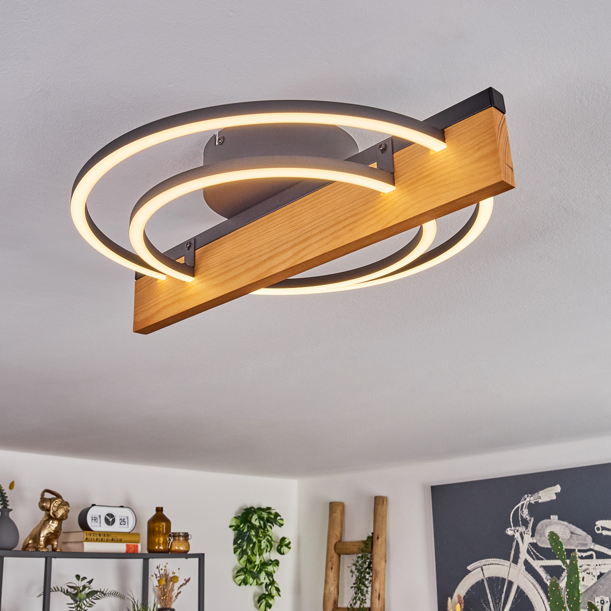 Eine moderne Deckenleuchte mit Holzbalken und kreisförmigen LED-Leuchten. Im Hintergrund sind eine weiße Decke und ein Wohnraum.