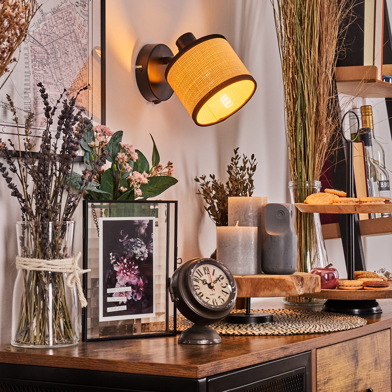 Ein Raum mit Lampe, Uhr, Blumen, Kerzen und Snacks auf einem Holztisch und Regalen. Dekorative Gegenstände sind platziert.