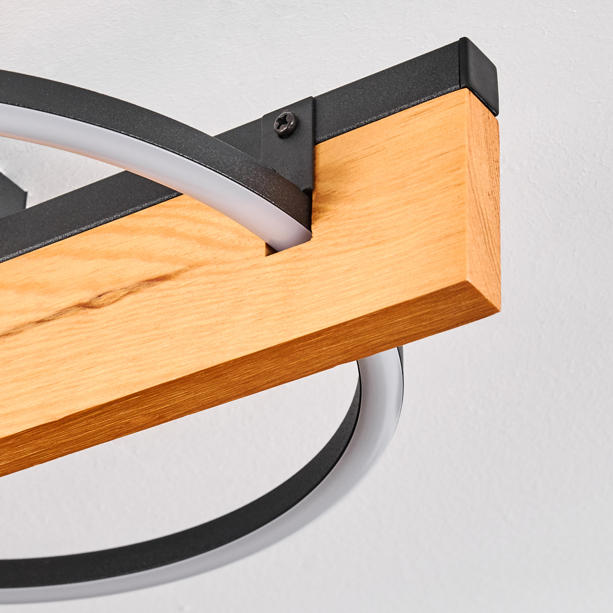 Eine moderne Leuchte. Sie verfügt über einen Holzbalken mit schwarzen Metallakzenten und einem gebogenen LED-Licht.