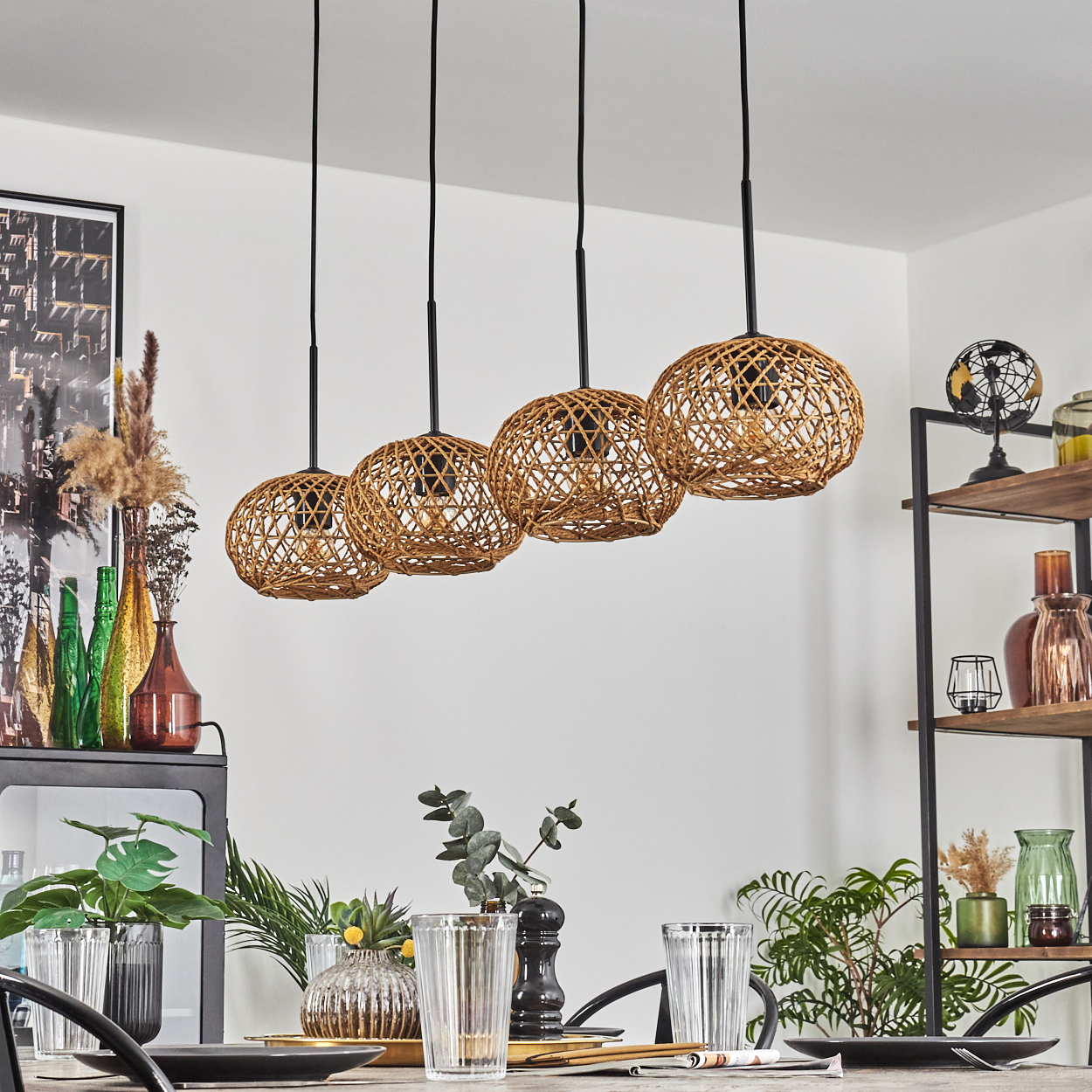 Esszimmer-Szene. Vier gewebte Pendelleuchten hängen über einem Tisch. Pflanzen, Vasen und ein Regal mit Dekoration im Hintergrund.