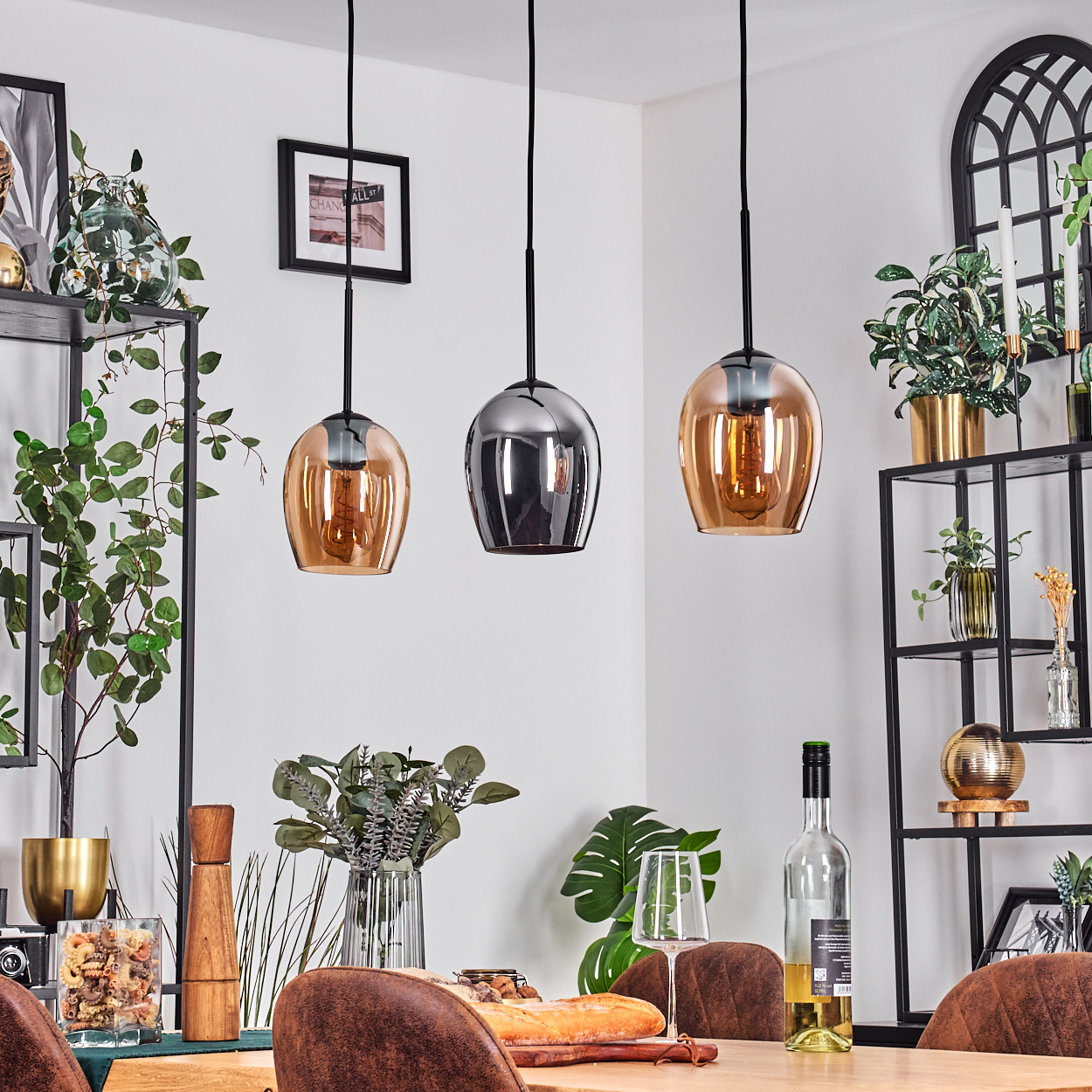 Esszimmer-Szene mit Hängelampen, Tisch mit Speisen und Getränken sowie dekorativen Regalen mit Pflanzen und Ornamenten.