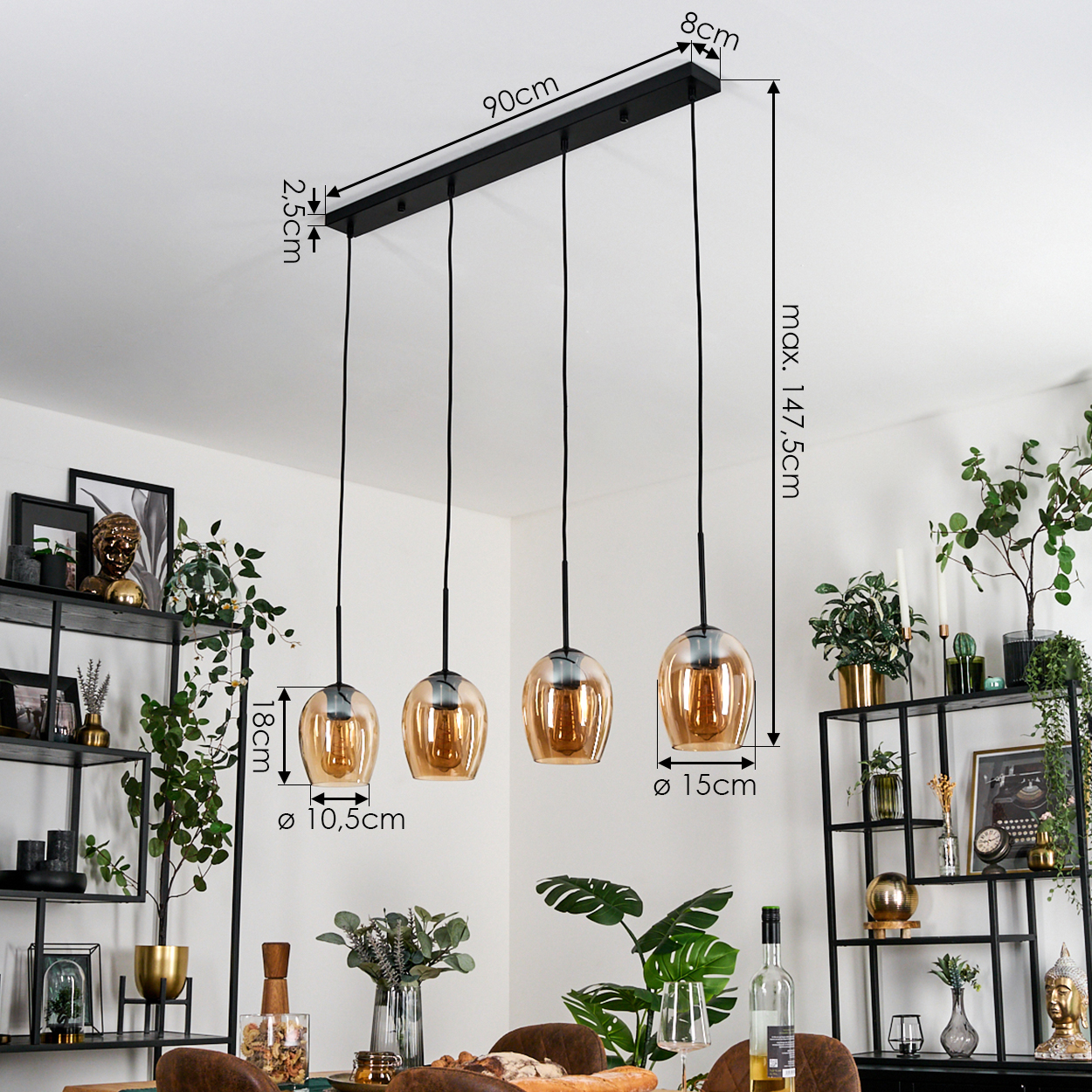 Eine moderne Pendelleuchte mit vier bernsteinfarbenen Glasschirmen hängt in einem Raum. Abmessungen sind beschriftet. Regale mit Pflanzen und Dekorationen im Hintergrund.