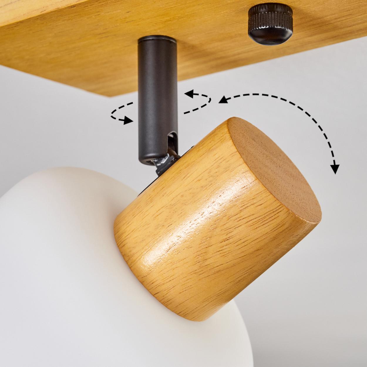 Ein hölzerner Lampenkopf ist mit einer schwarzen Stange verbunden, die an einem hölzernen Deckenelement befestigt ist. Der Kopf ist angewinkelt.