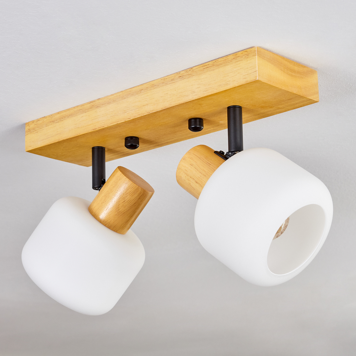 Deckenleuchte mit zwei weißen Lampen, Holzakzenten und Holzbalken. An einer weißen Decke montiert.