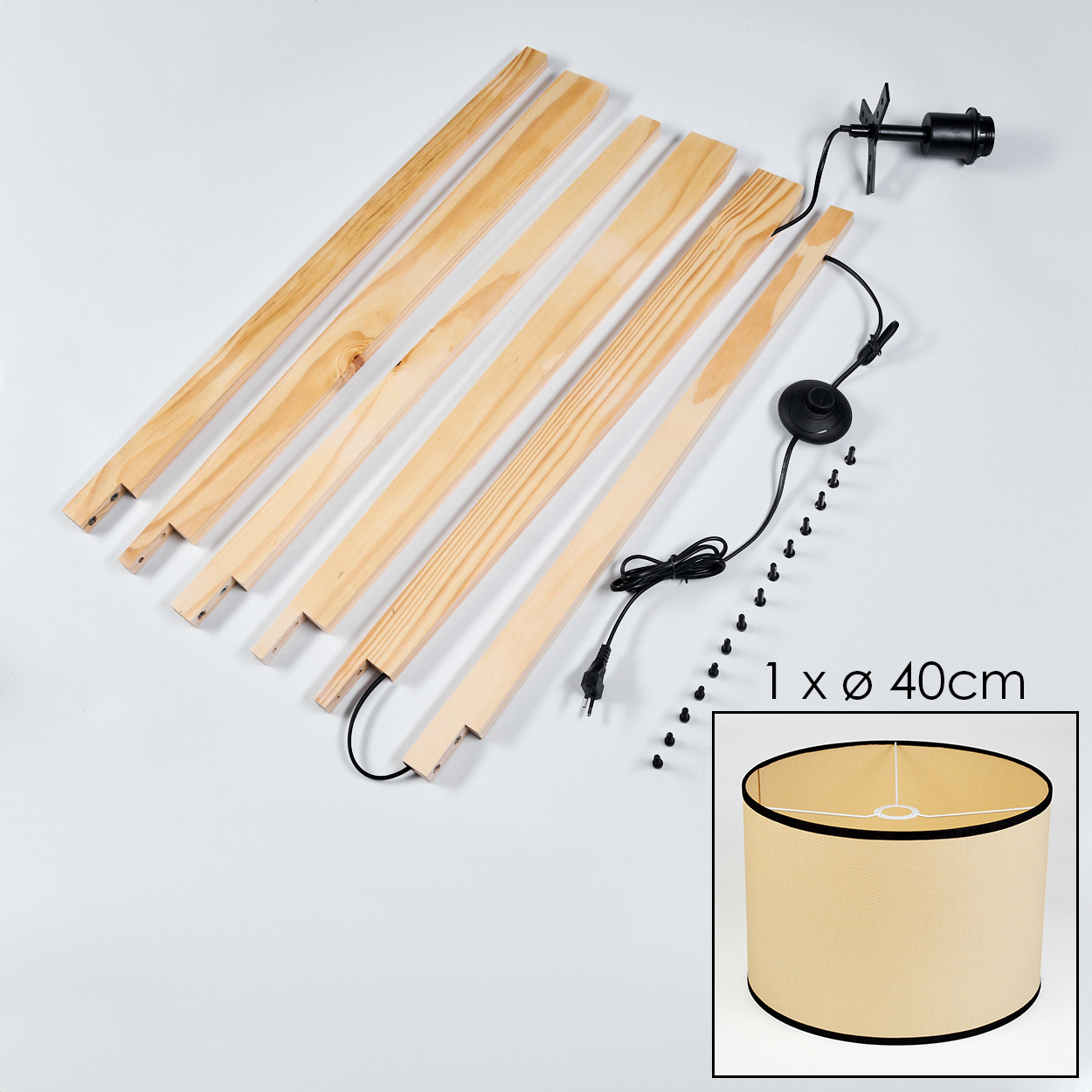 Lampenteile: Holzlatten, schwarze Elektrik, Lampenschirm und Schrauben auf weißem Untergrund. Der Schirm ist beige.
