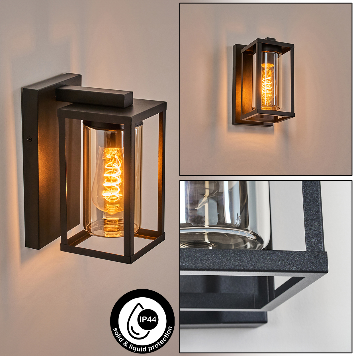 Schwarze Wandlampe mit Glaskylinder und bernsteinfarbener Glühbirne. Die Lampe hat einen quadratischen Rahmen und ist an der Wand montiert.