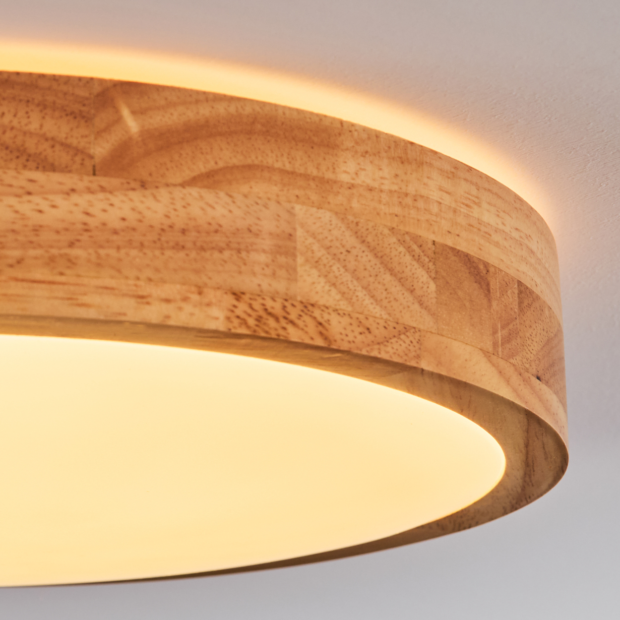 Nahaufnahme einer hölzernen Lampe mit warmem Schein. Die Lampe ist rund mit einem Holzrahmen und einer leuchtenden Oberfläche.