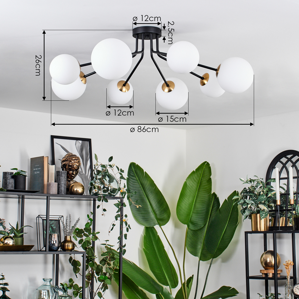 Eine moderne Deckenlampe mit weißen Kugeln und schwarzen Armen. Darunter ein Raum mit Pflanzen und Dekorationsartikeln auf Regalen.