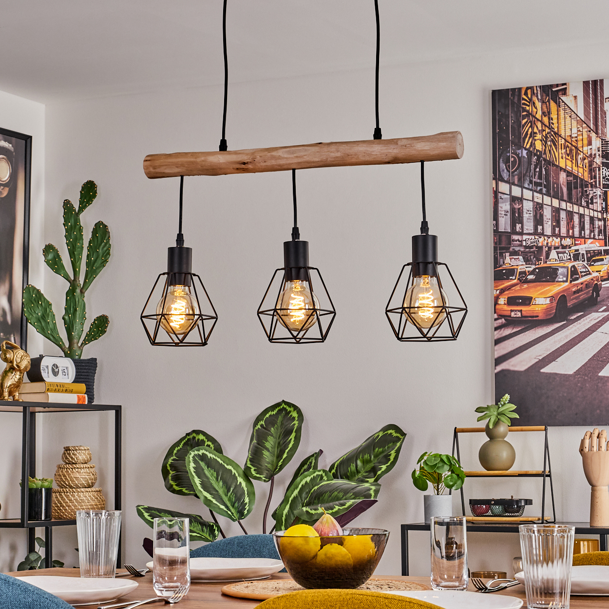 Ein Esszimmer mit Holztisch, drei Hängelampen, Pflanzen und einem Stadtbildgemälde an der Wand.