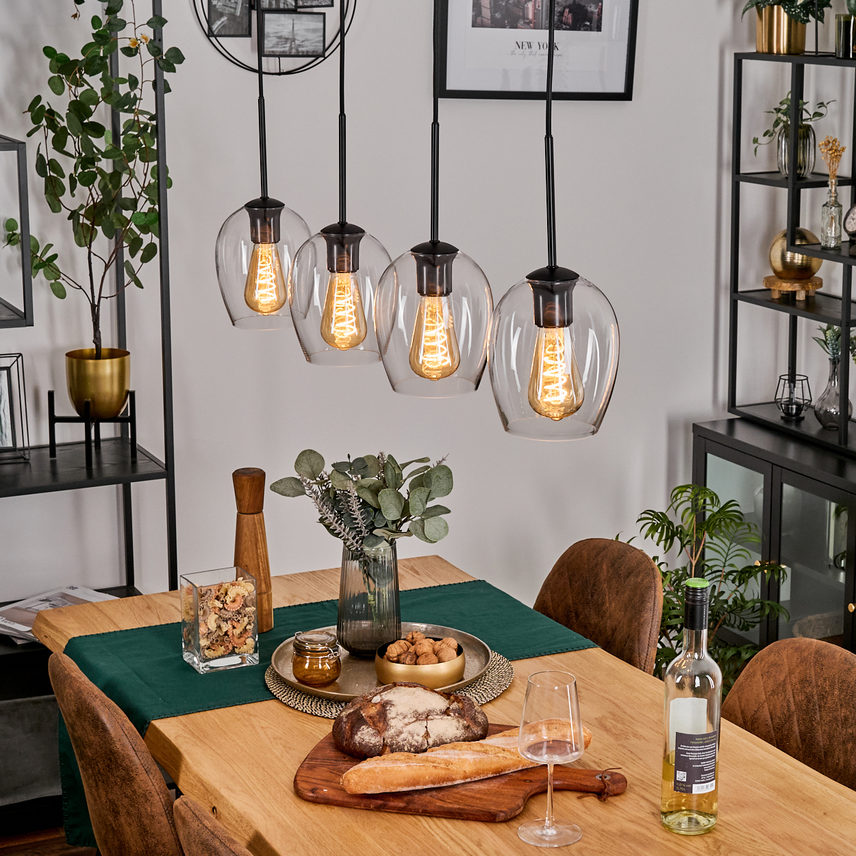 Esszimmer-Szene. Glaskugelleuchten hängen über einem Tisch, der mit Essen, Wein und Gläsern gedeckt ist. Im Hintergrund befinden sich eine Pflanze und Regale.