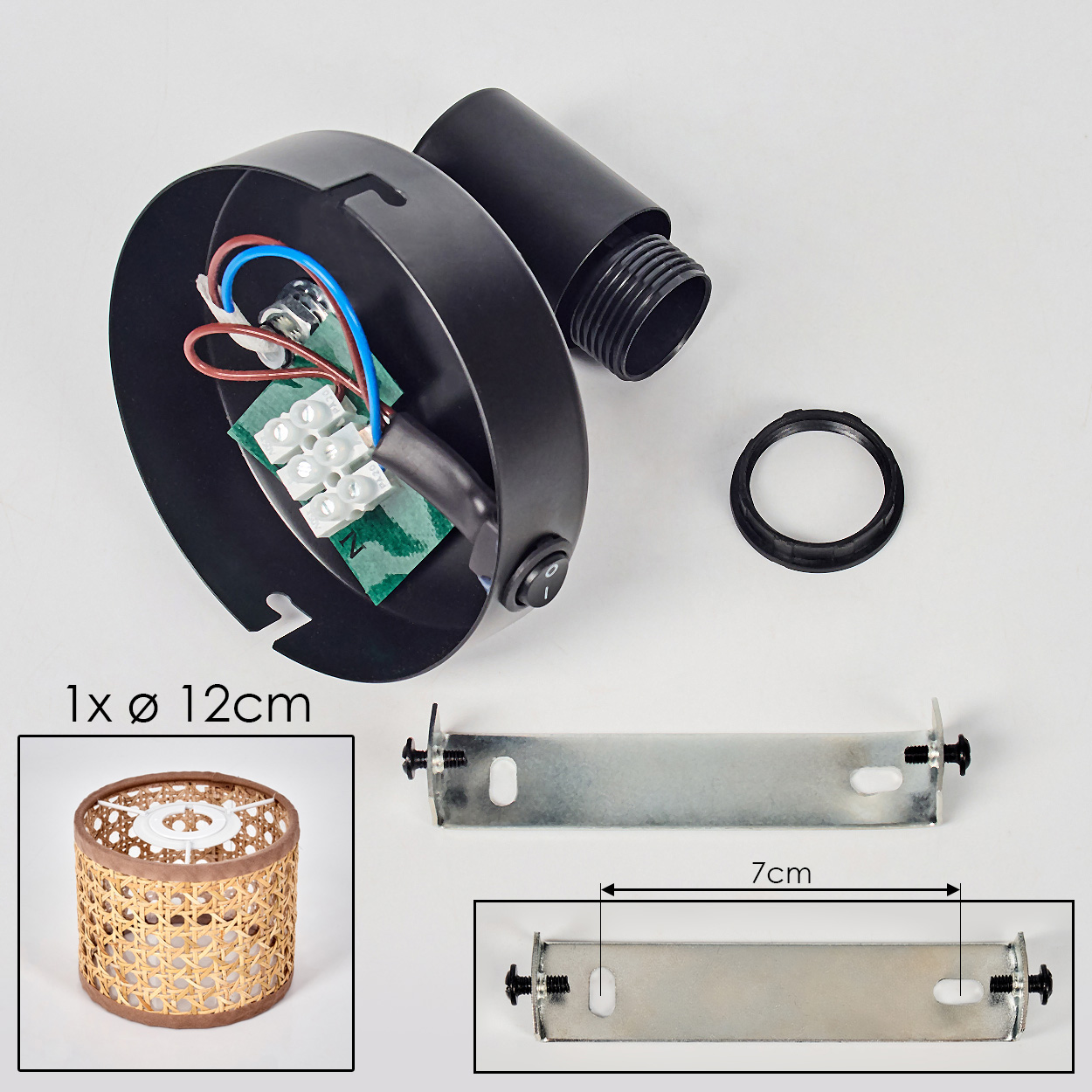 Schwarze Lampenteile: ein kreisförmiger Rahmen, ein Rohr, ein Ring, ein Metallstab und ein Lampenschirm aus Korbgeflecht. Drähte und ein Schalter sind ebenfalls sichtbar.
