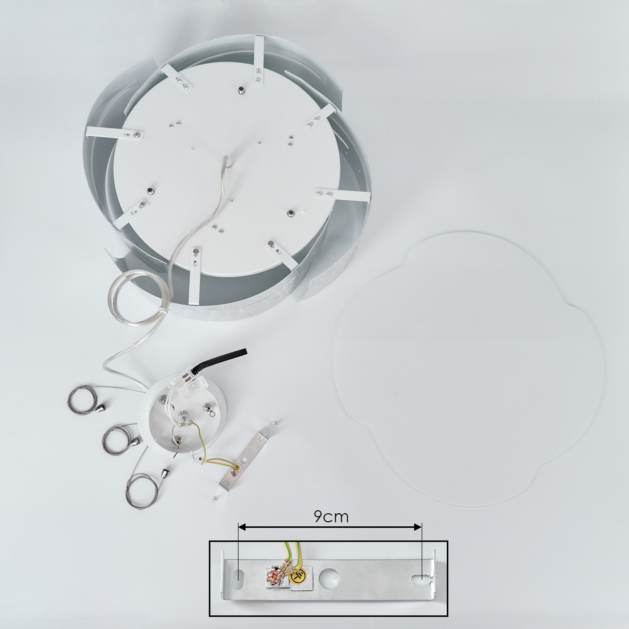 Zerlegte Deckenlampe mit weißem Sockel und silbernen Akzenten. Teile umfassen Drähte, Montagehalterung und eine transparente Abdeckung. 9cm Messung wird gezeigt.
