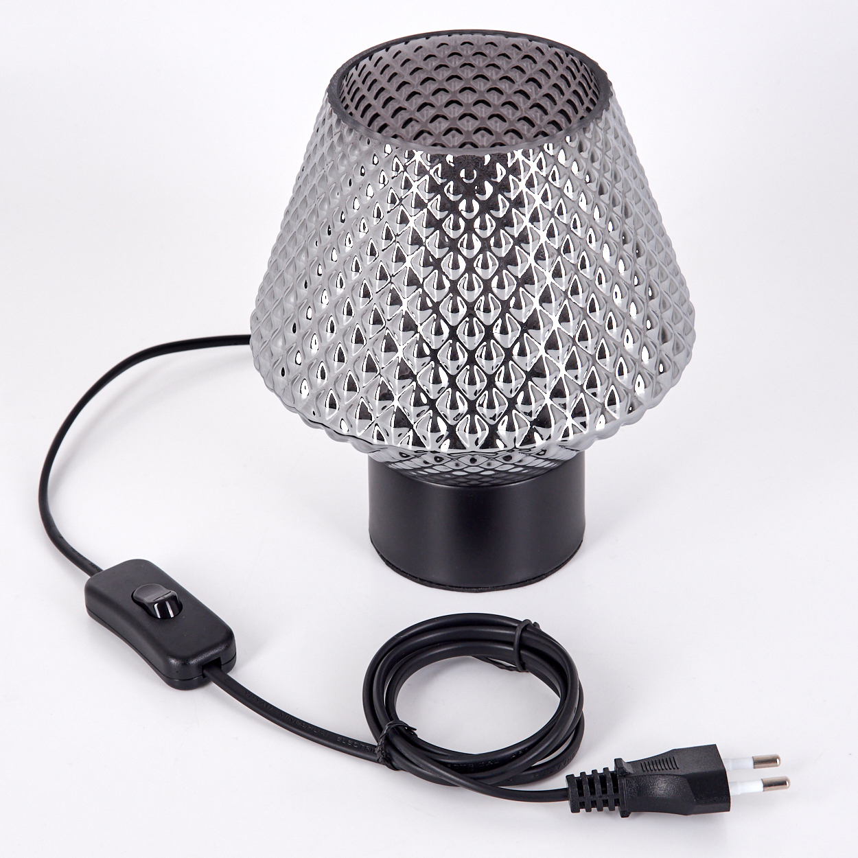 Silberne Lampe mit strukturiertem Schirm, schwarzem Sockel und Netzkabel mit Schalter und Stecker auf weißem Untergrund.