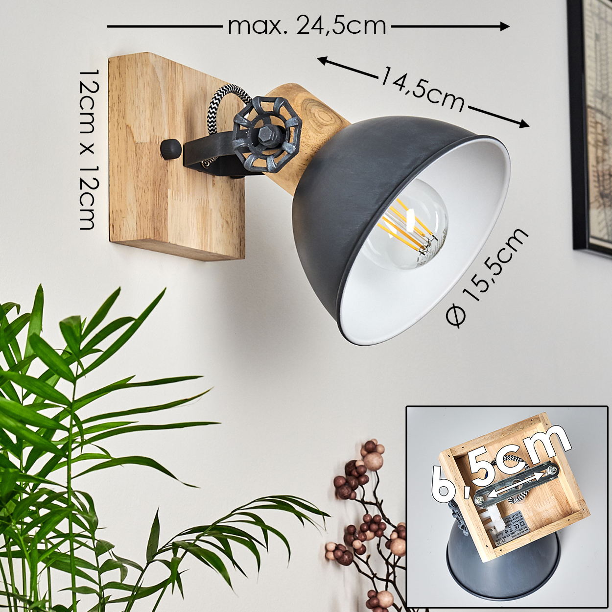 Eine Wandlampe mit Holzsockel und schwarzem Lampenschirm. Maße sind angegeben. Pflanzen und eine kleine Holzkiste im Bild.