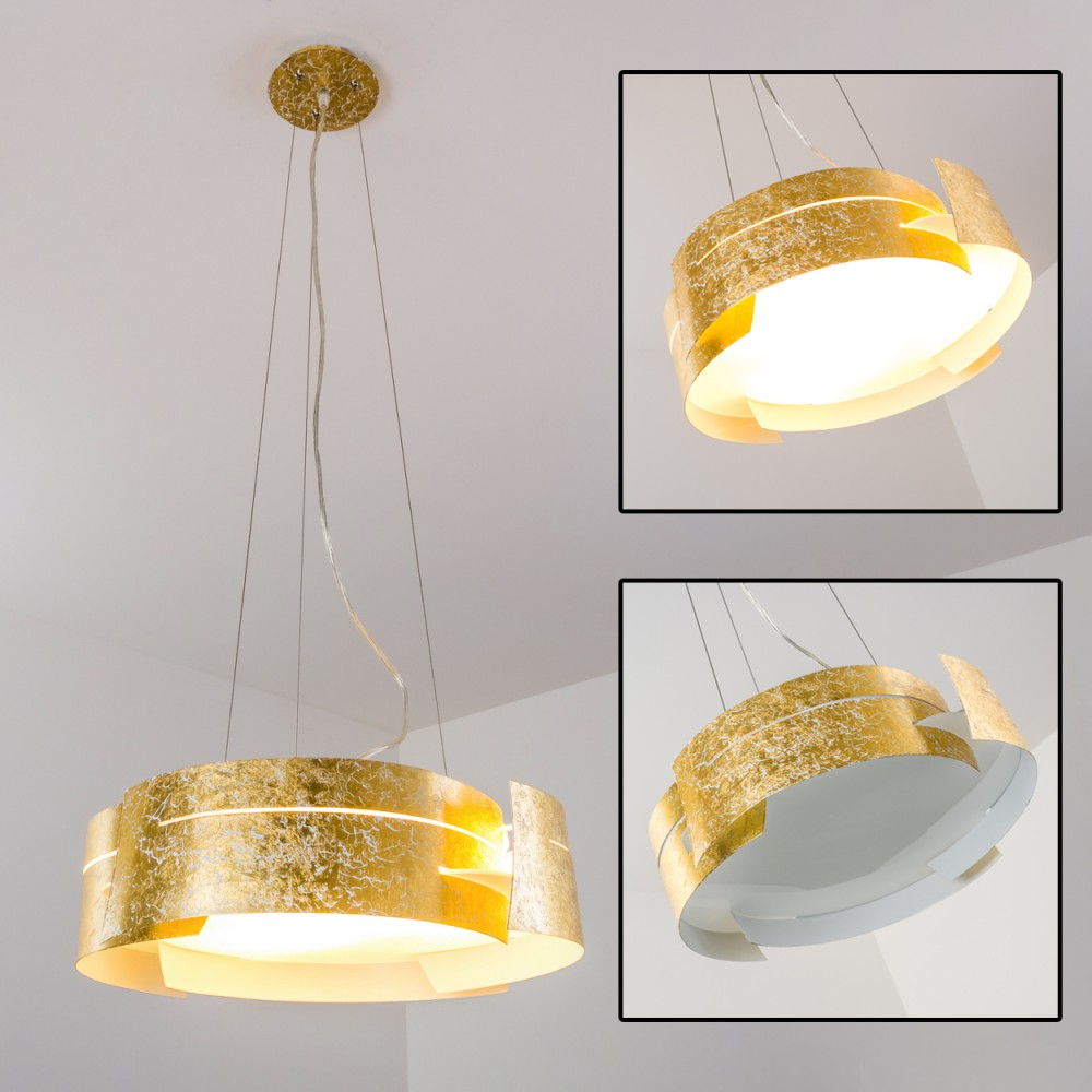 Eine goldene, kreisförmige Deckenlampe mit strukturierter Oberfläche, die an dünnen Drähten hängt, beleuchtet eine weiße Decke.