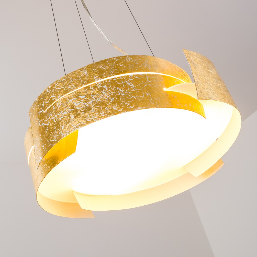 Eine Pendelleuchte mit Blattgold hängt von der Decke. Es hat ein kreisförmiges Design mit hellem Licht im Inneren.