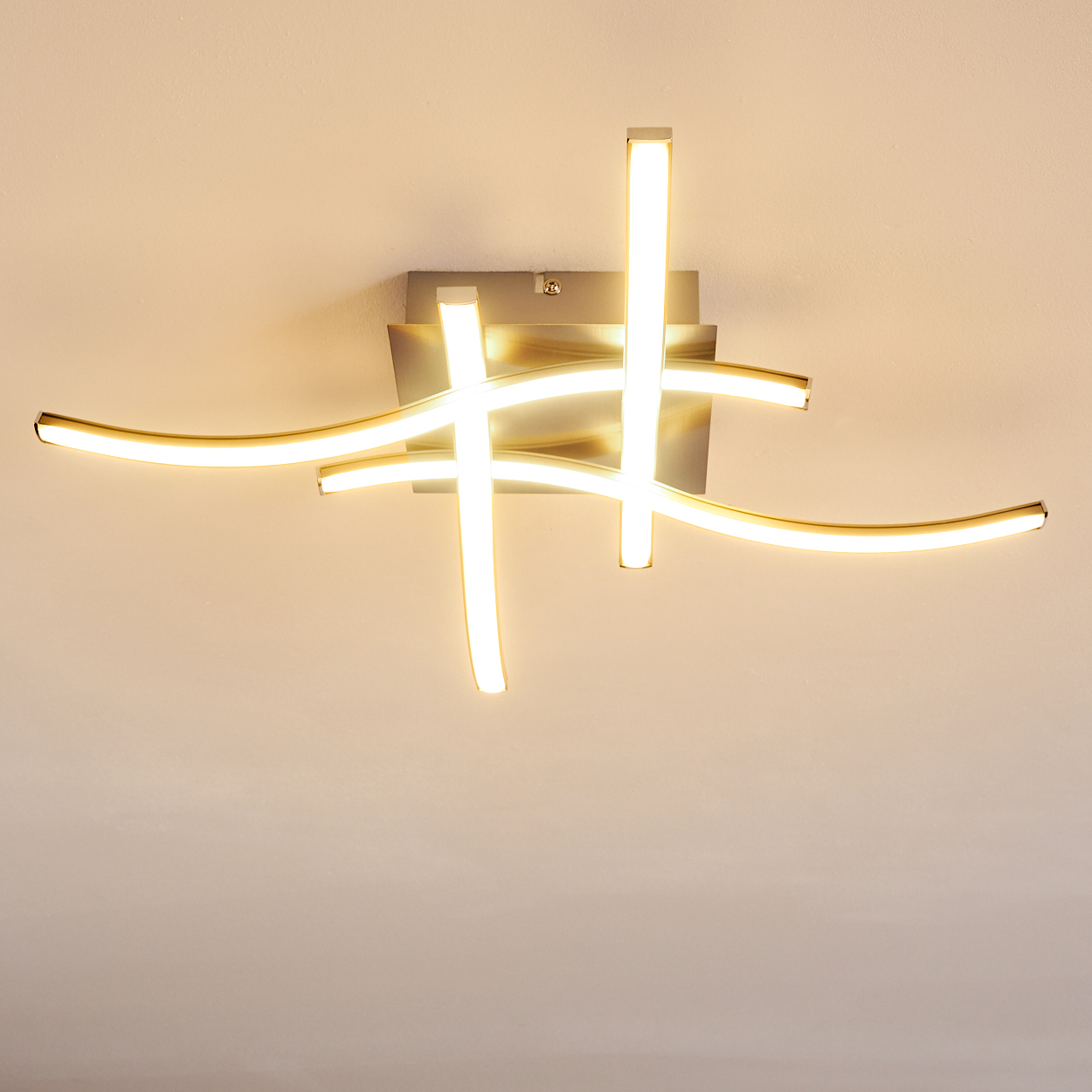 Eine moderne Deckenleuchte mit gebogenen und geraden Leuchtstäben. Das Licht ist auf einer quadratischen Metallbasis an einer weißen Decke montiert.