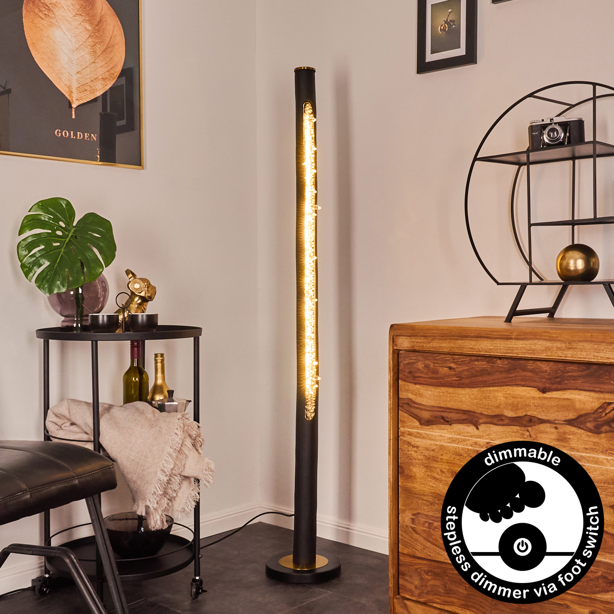 Eine hohe, schwarze Stehlampe mit kleinen Lichtern beleuchtet einen Raum mit Möbeln, Kunst und einer Grafik des Dimmers.